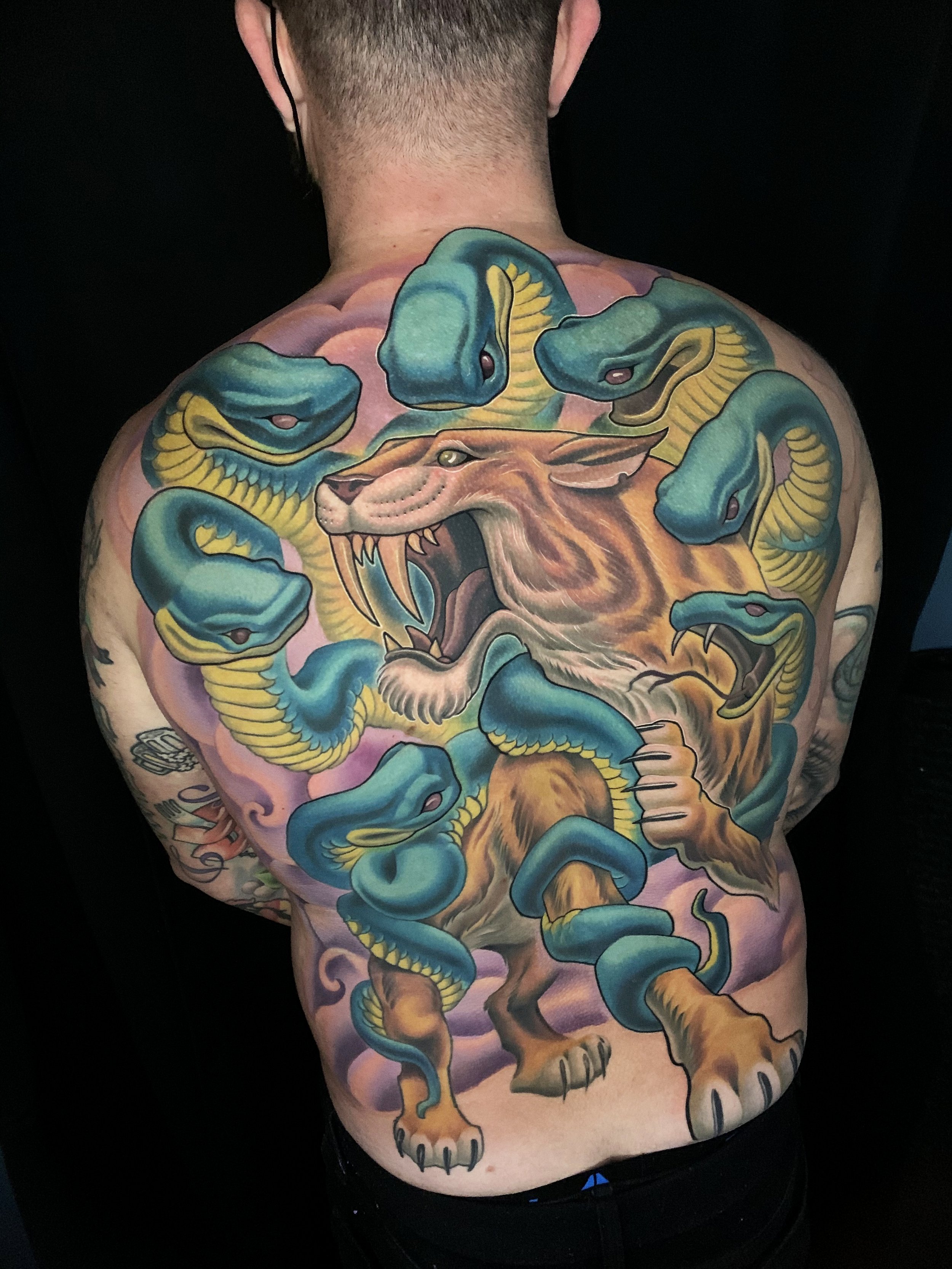 Saber tooth cat and snakes backpiece tattoo
