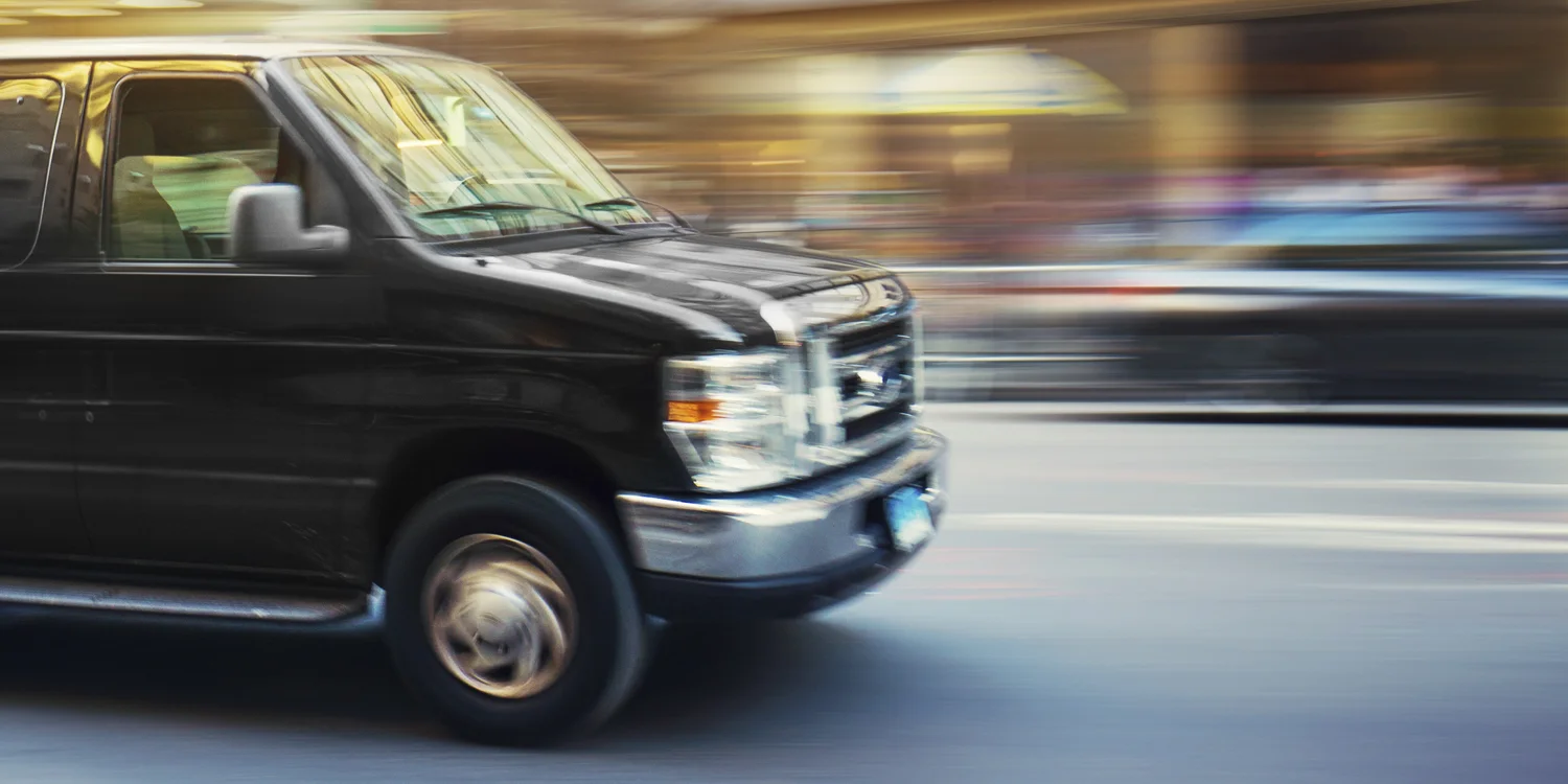 Moving grey van blurred by speed.