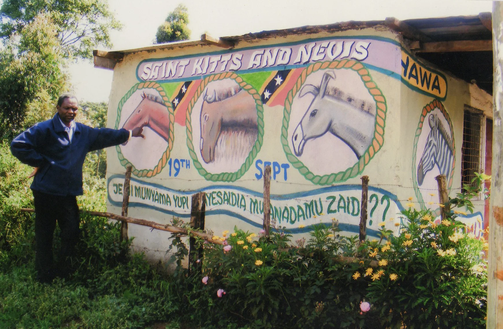 Fredrick Mbuga creates a mural in Ngecha, Kenya, for the people of Saint Kitts & Nevis on their independence day (Sept 19).