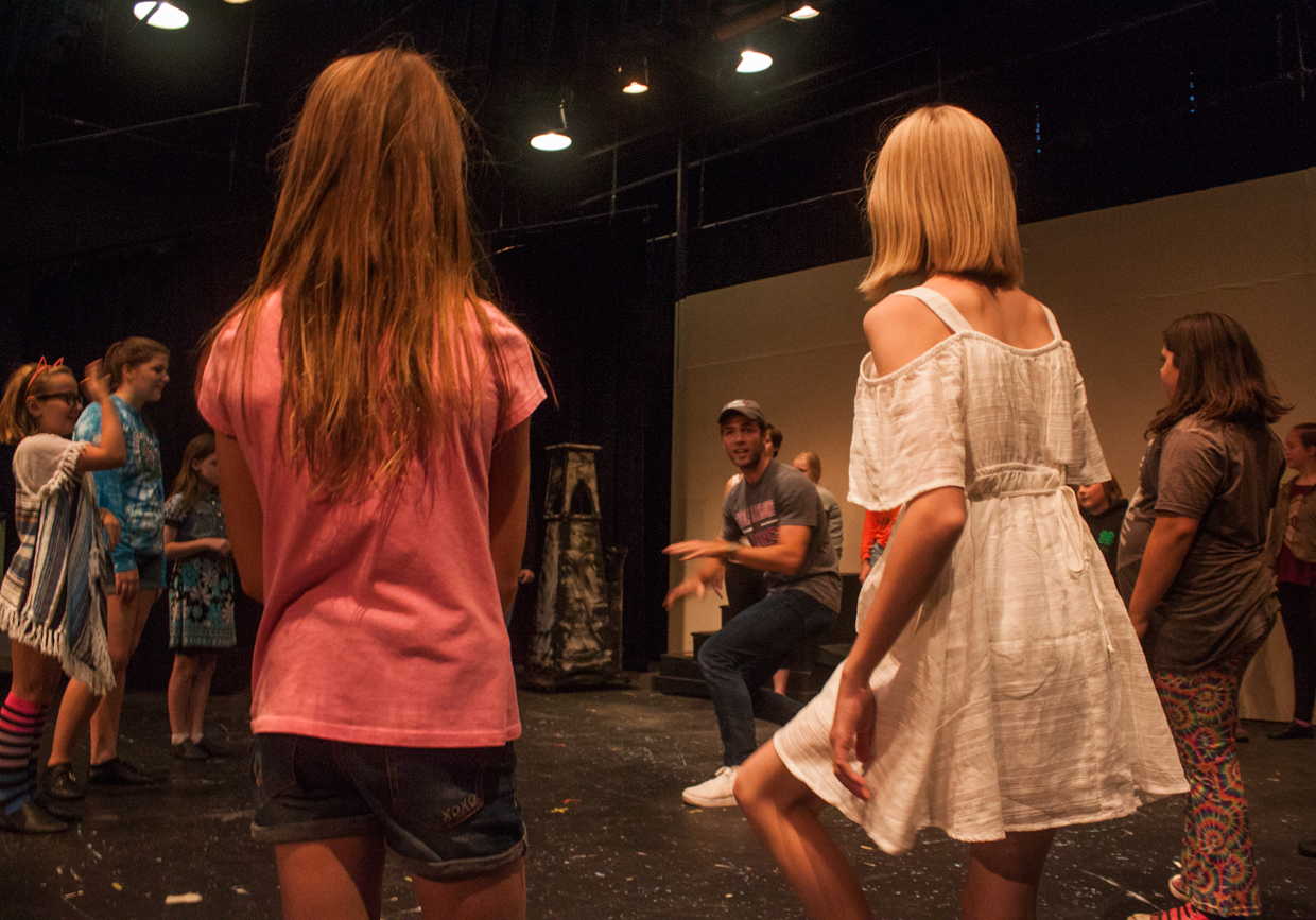 Annabella Harrison (Michael Banks) and Chloe Cranch (Jane Banks) look on as Director, Ty Molbak works choreography with the Chimney Sweeps for Step in Time. Photo by Kathryn Lynn Morgen