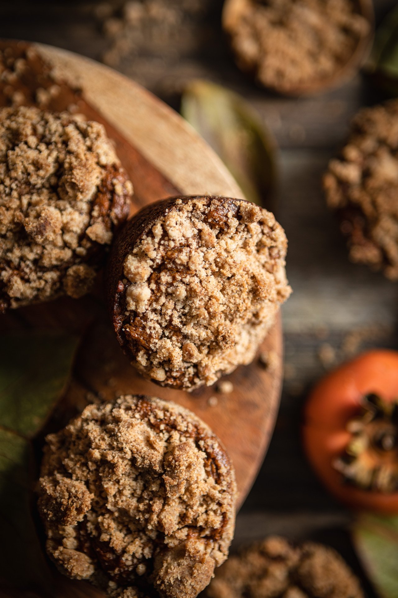 Persimmon Muffins with Crumb Topping on dark wooden background