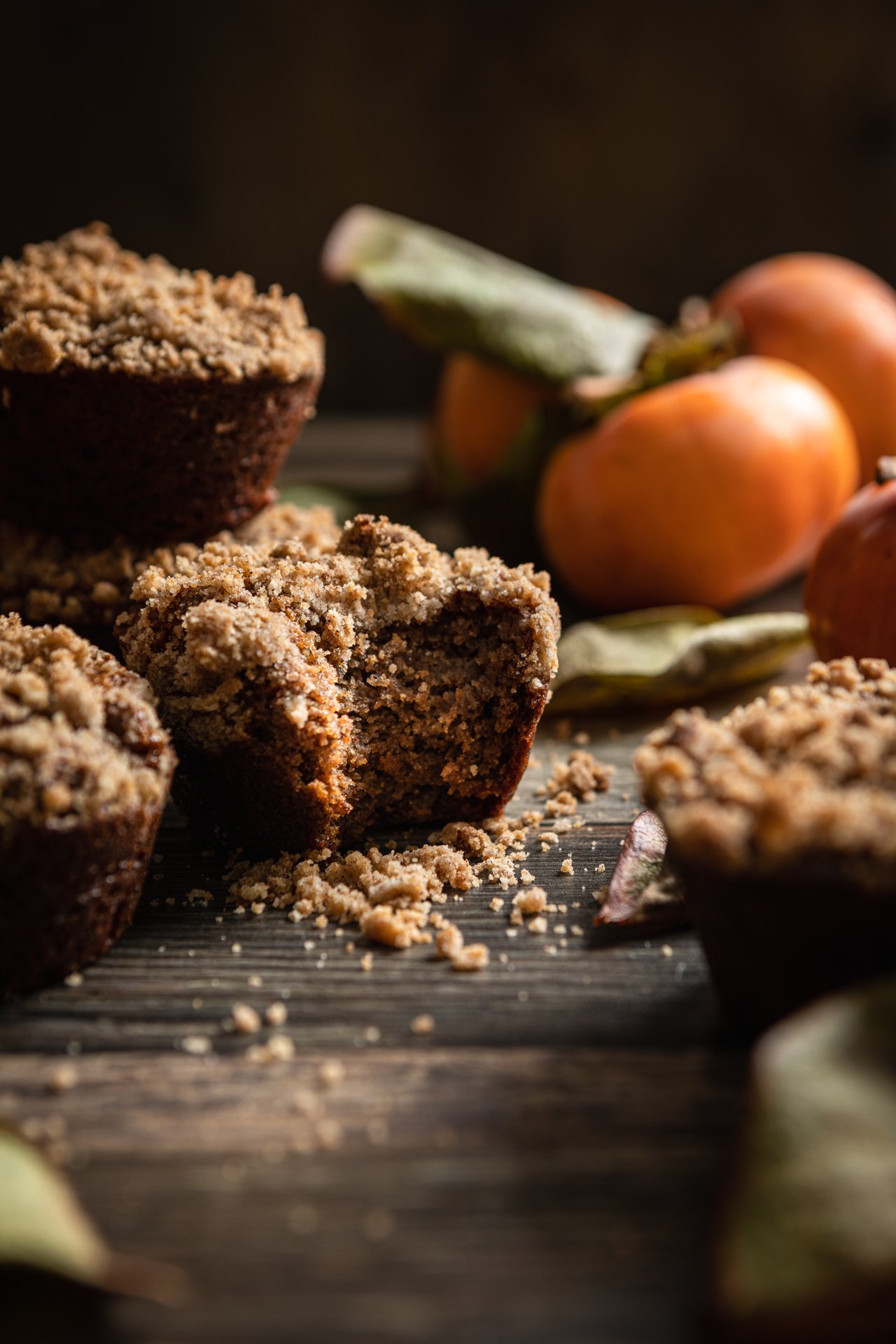 Persimmon Muffins with Crumb Topping on dark wooden background