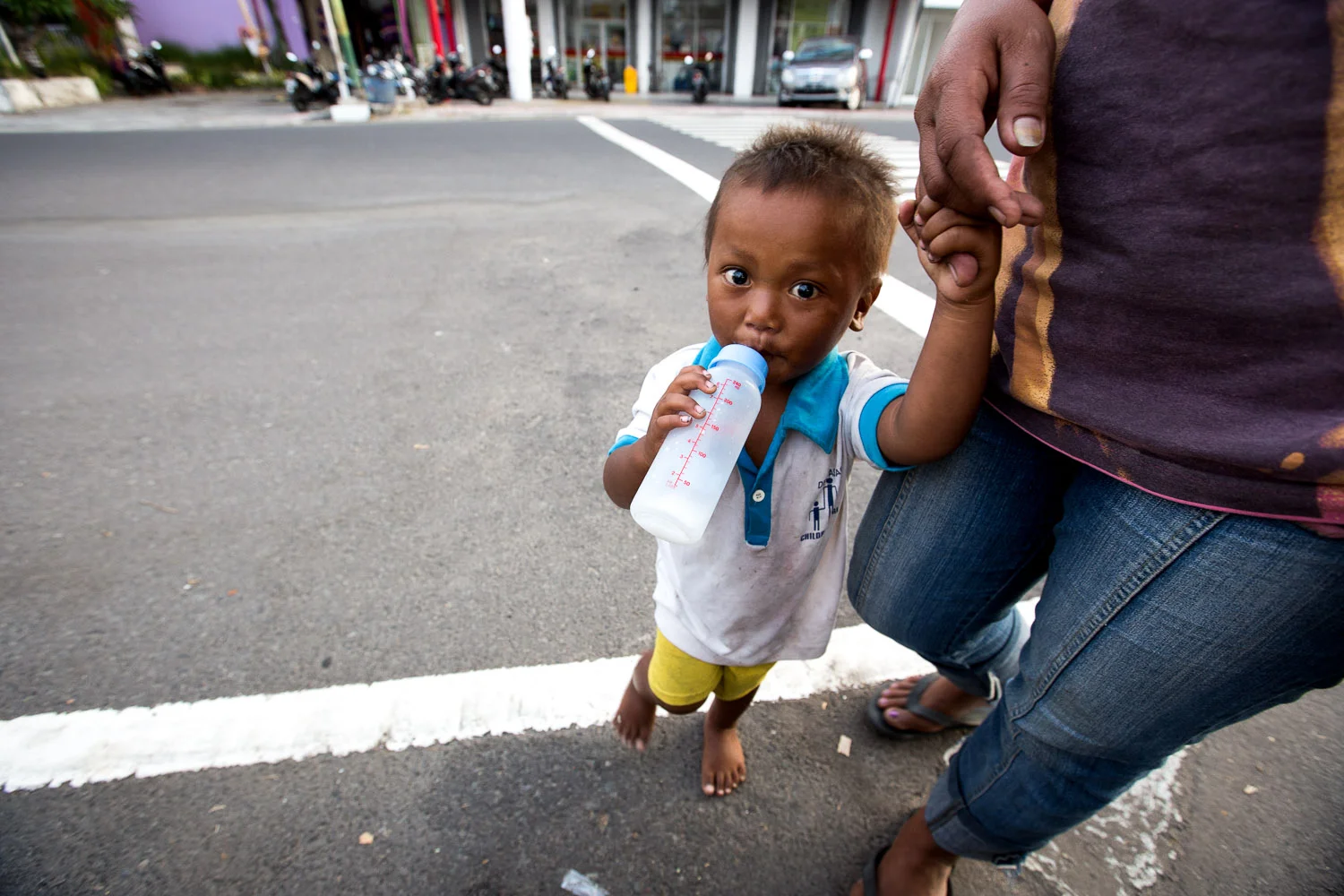 A mom and her son begging in the streets of Denpasar, Bali.