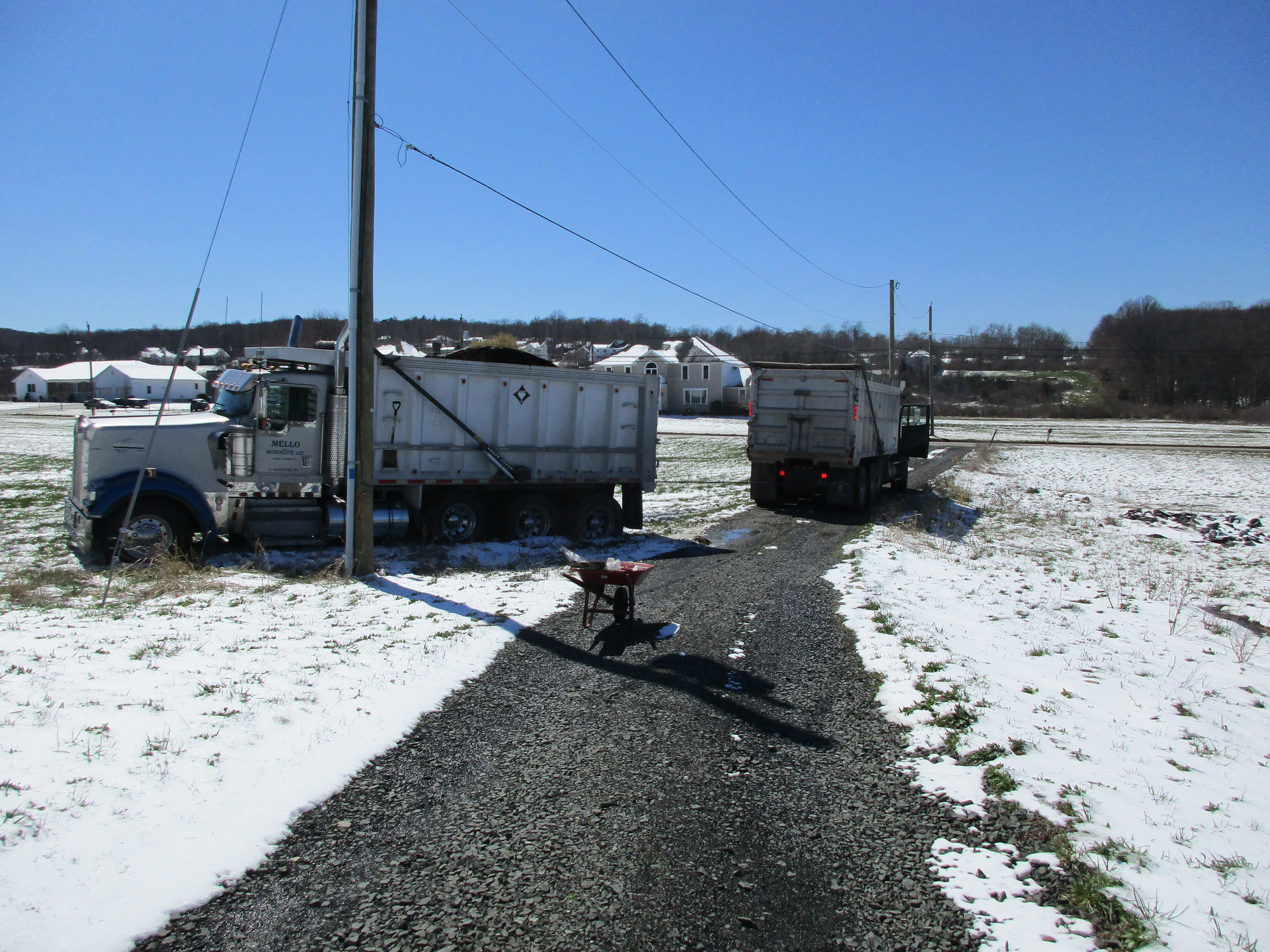 Truck on left with our compost being pulled out with a chain attached to truck on the driveway