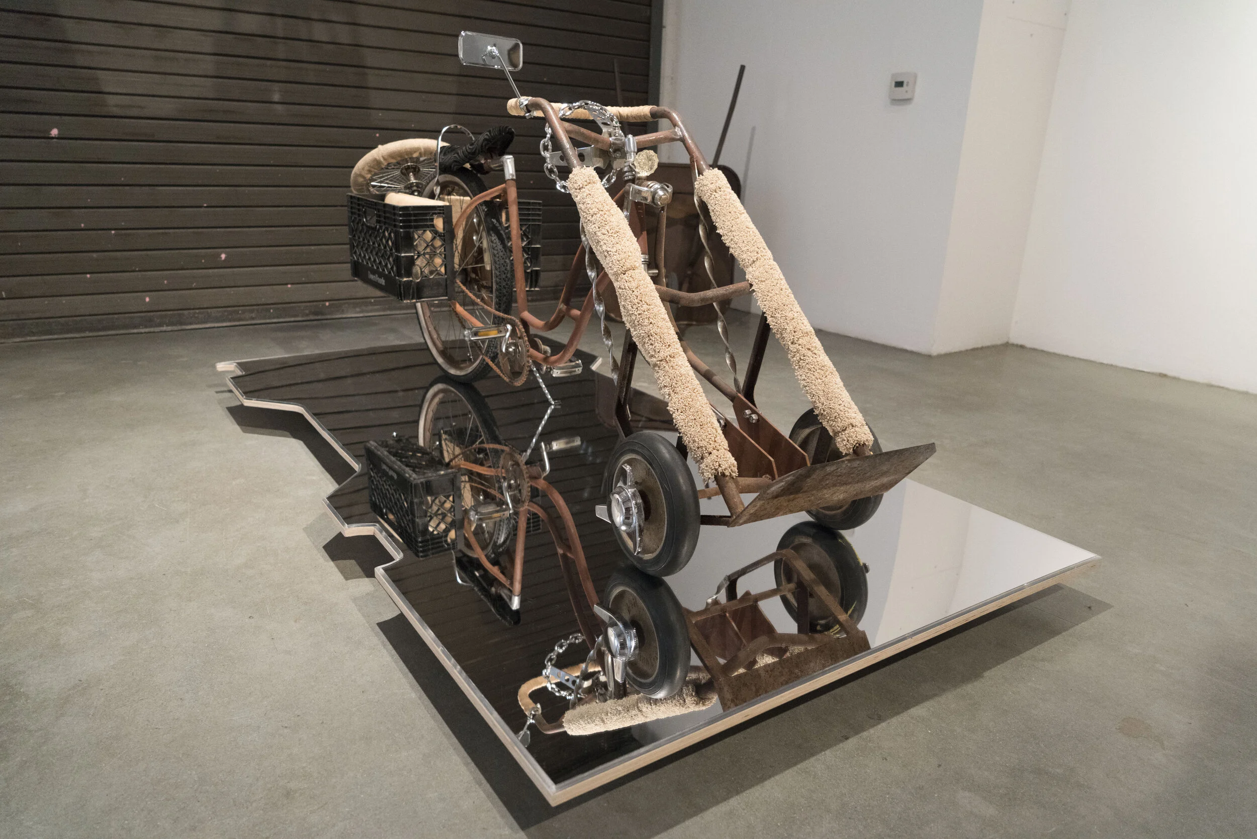   Dear Juan ,  2019  dolly, lowrider bike parts, burlap, carpet, milk crate, sleeping Mexican steel perfume bottle, and mirror stand 32 x 91 inches, 1/4 x 49 3/4 inches.  © Copyright 2025. All rights reserved.  