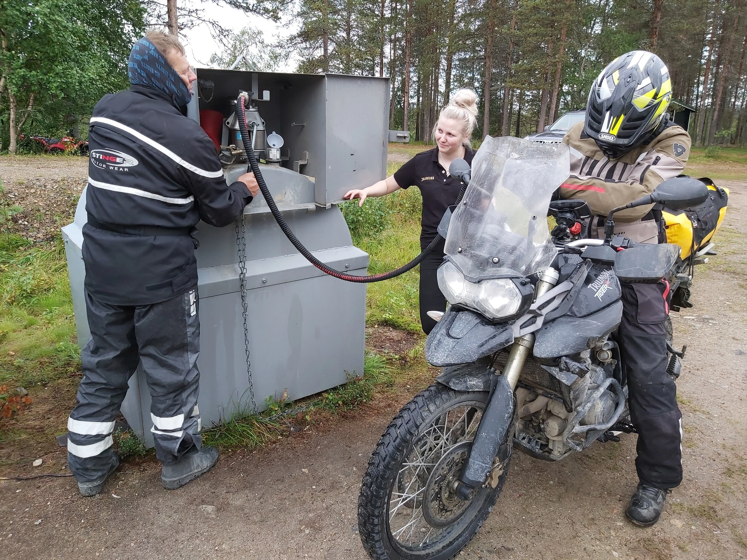 Juhani pumppaa ja Jaakko tankkaa. Neito katsoo päältä että homma toimii.