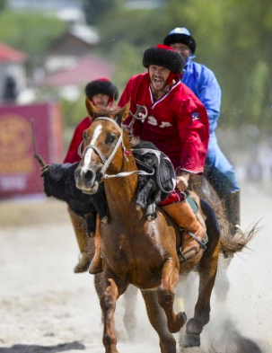 A U.S. participant rides with the 70-pound goat carcass to his taikazan, or goal. “It’s like rugby on horses,” captain Creed Garnick told The Washington Post. (Vladimir Voronin/AP)