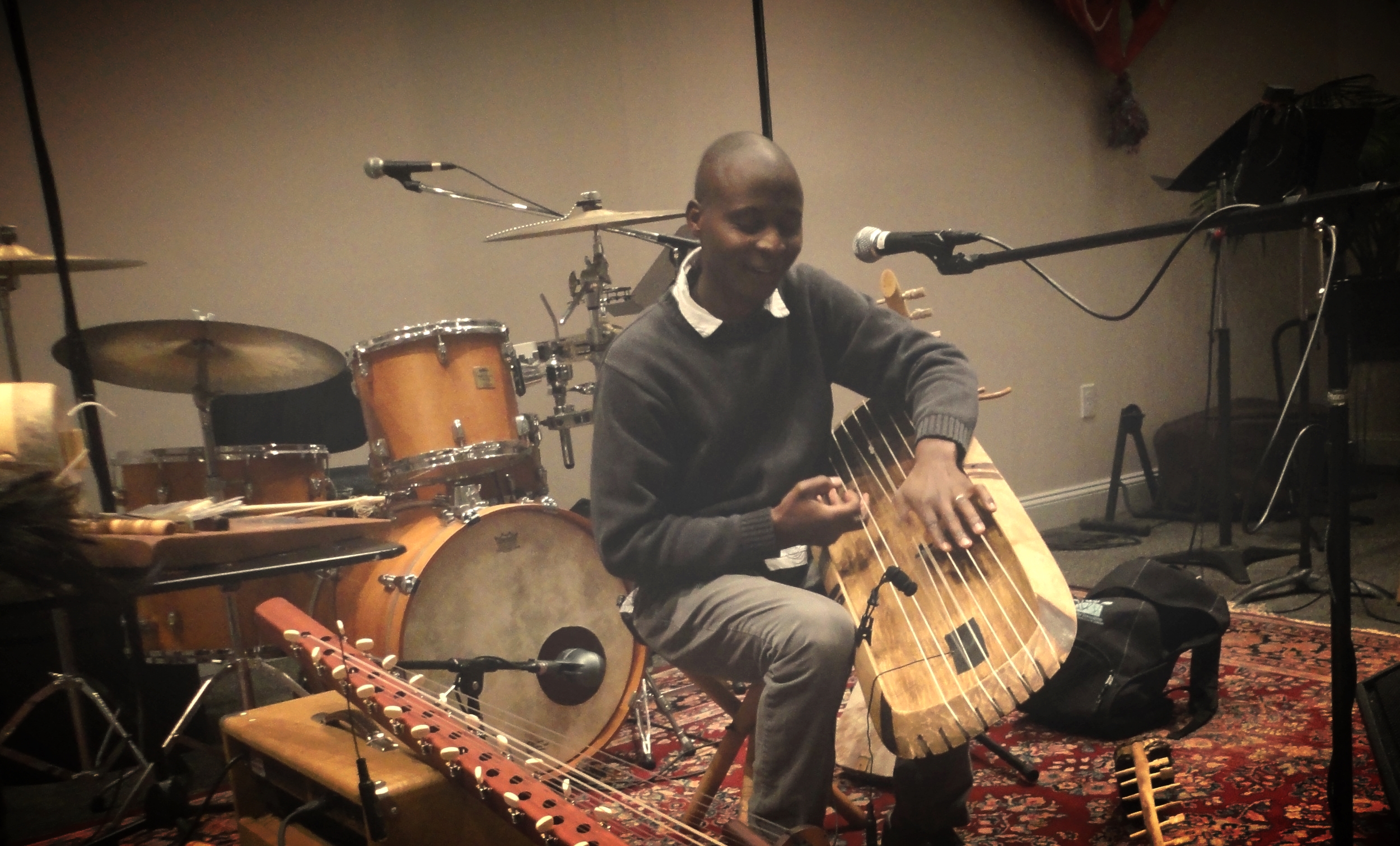 Gideon Ampere is a master musician and instrument maker from Uganda, East Africa. Gideon shares the music and dance of his homeland with any and all who will listen, appreciate, and participate. He has experience performing on several Ugandan folk instruments including zithers, bow harps, tube fiddles, lyres, flutes, thumb pianos, panpipes, log xylophones and drums. Gideon has participated in workshops and artists gathering over many years as part of the CT Cultural Heritage Arts Program. He has a Master of Arts in ethnomusicology from Wesleyan University and a Bachelors of Arts from the University of Connecticut.