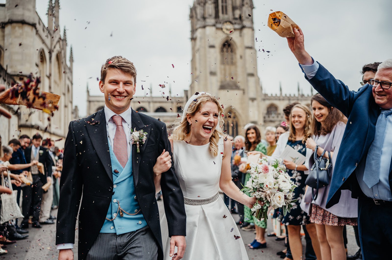 guests throw confetti over bride and groom in oxford 
