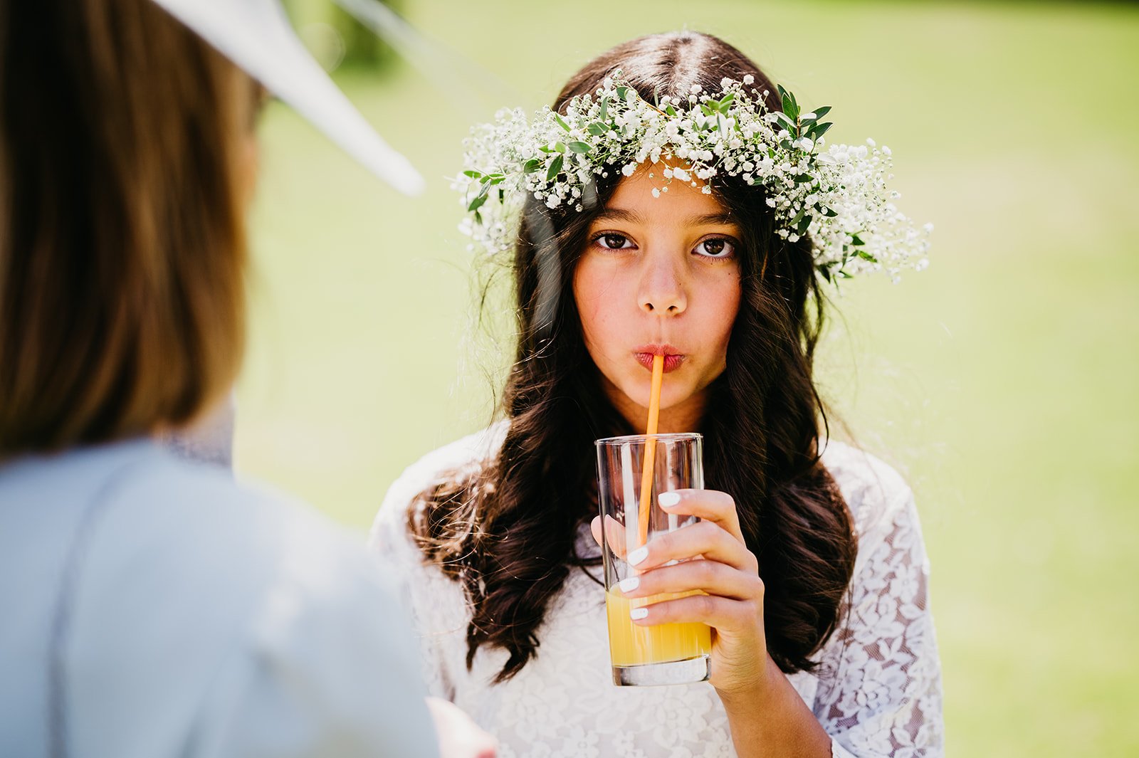 flower girl wearing crown drinks through a straw at lains barn