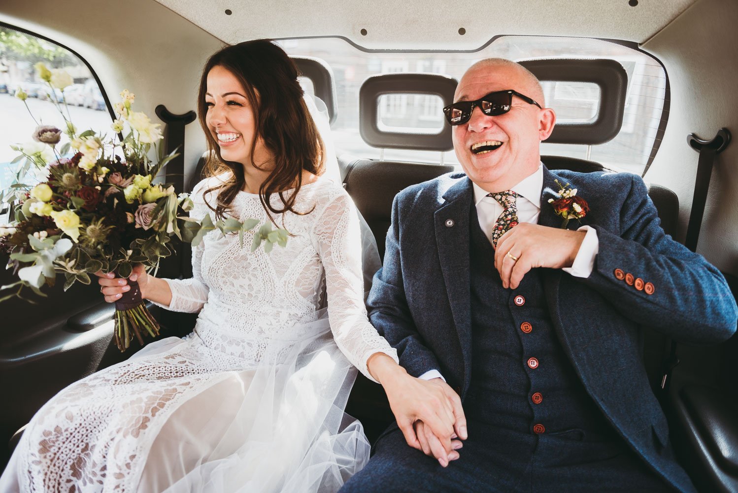 bride laughs with her dad in the taxi.jpg