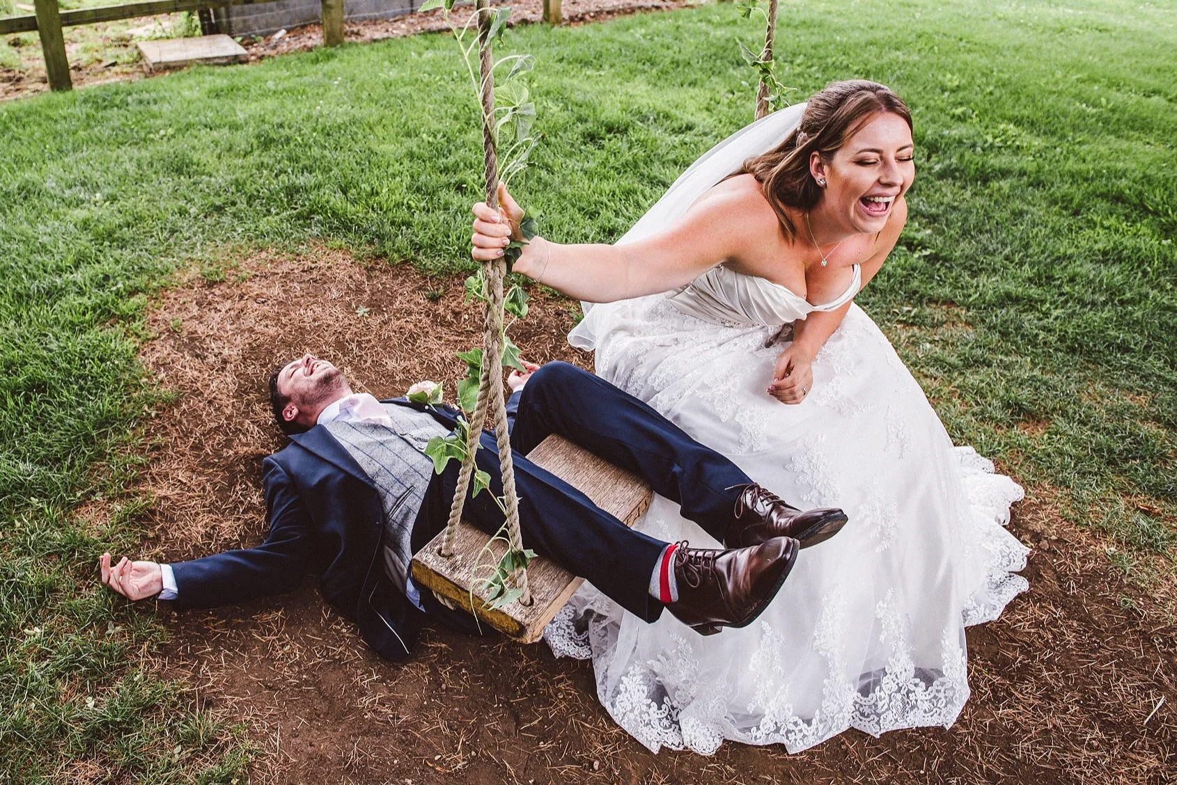 bride+and+groom+play+on+a+swing.png