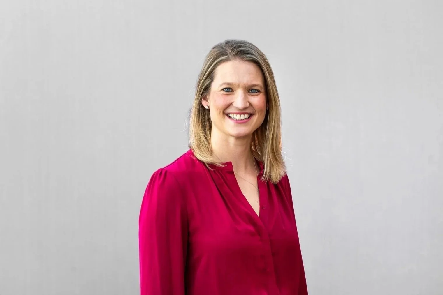 female corporate headshot with grey background