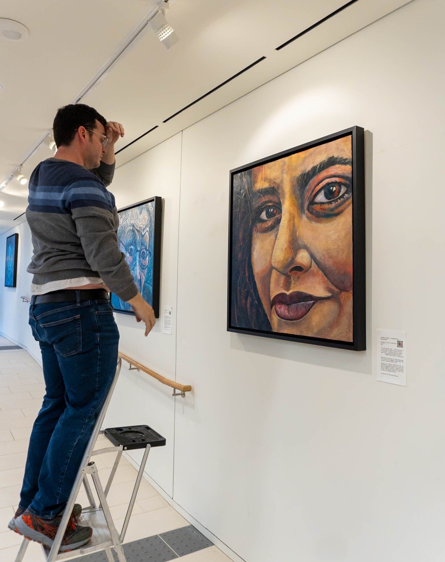 Justin Castellano contemplating the lighting of my encaustic painting Loosely Lucretia &mdash; Impression of Mahsa Amini in the gallery at Holy Blossom Temple, Toronto. The exhibition runs until June 4. .
.
#figurativeart 
#expressionism 
#portraitur