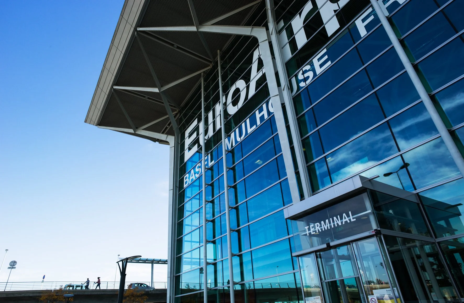 Photographie d'architecture: Vue de l'extérieur d'un terminal d'aéroport moderne avec une façade en verre