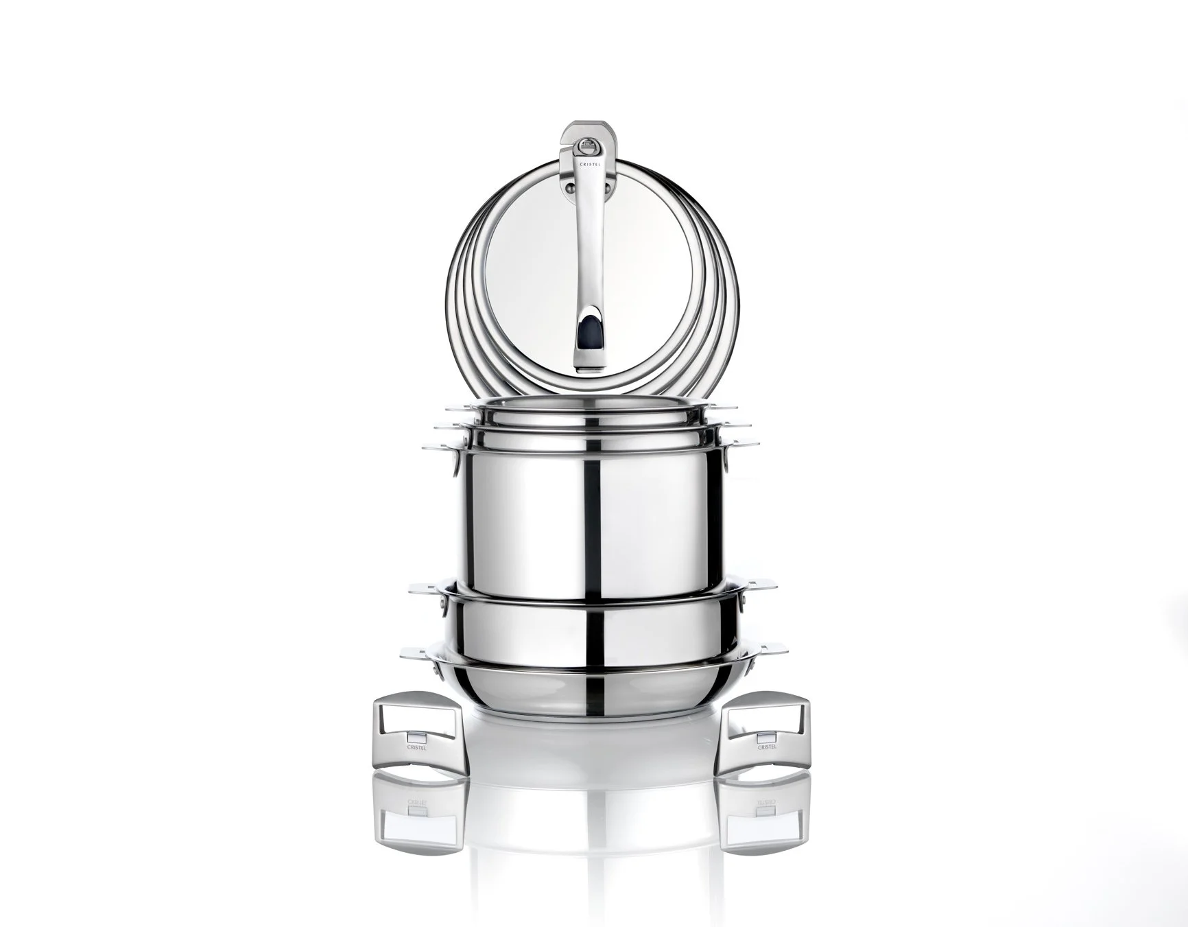 Une collection de casseroles et poêles de la marque Cristel en acier inoxydable empilées, avec un couvercle placé en haut.