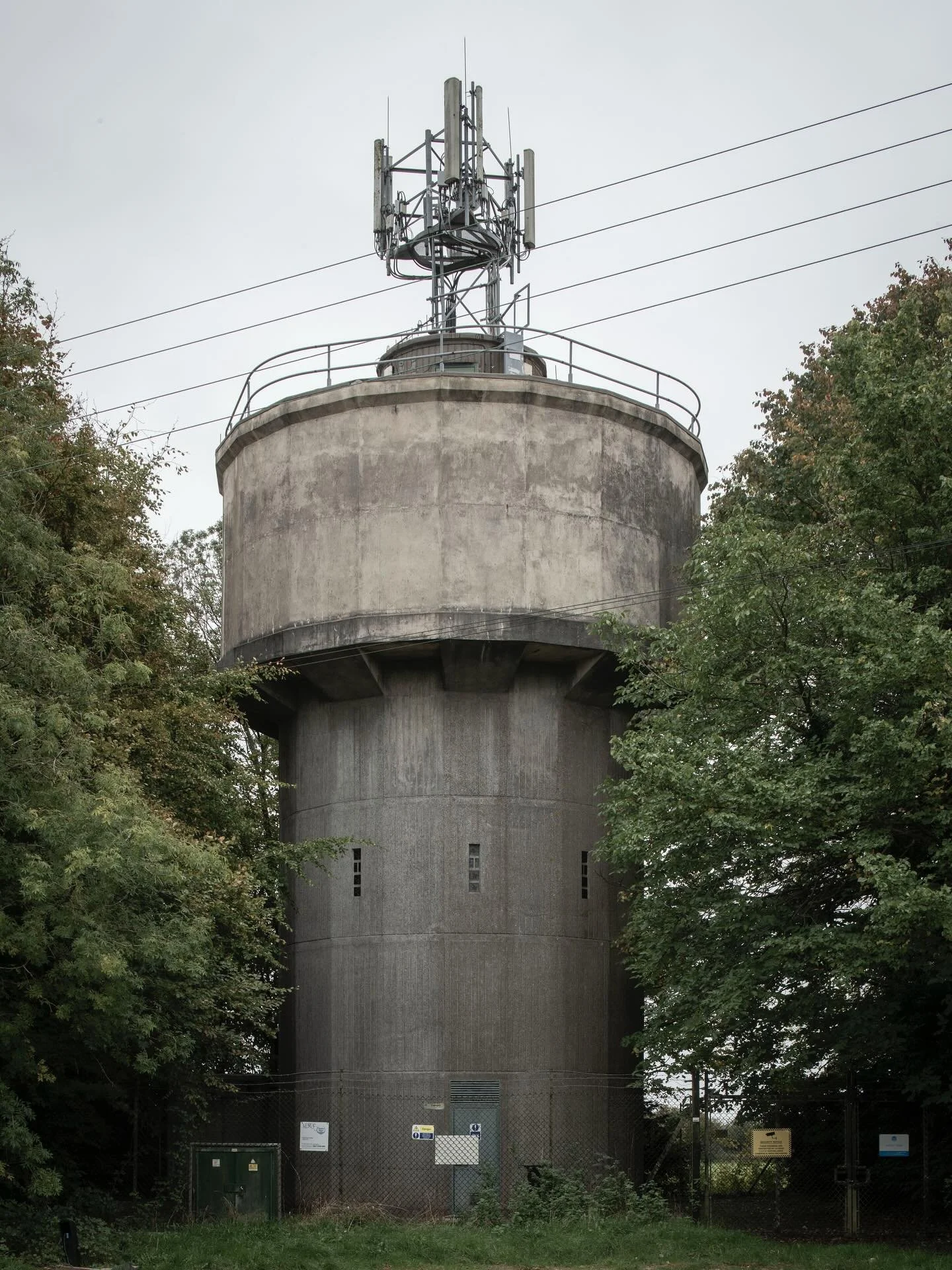 #003 Water/Cell Tower
A robust unit, some nice shuttering, but the most curious bit are the windows, which look like they are made from stained glass.

Tarlton, Gloucestershire.
#objectsinthelandscape #celltower #watertower #thameswater #sourceofthet