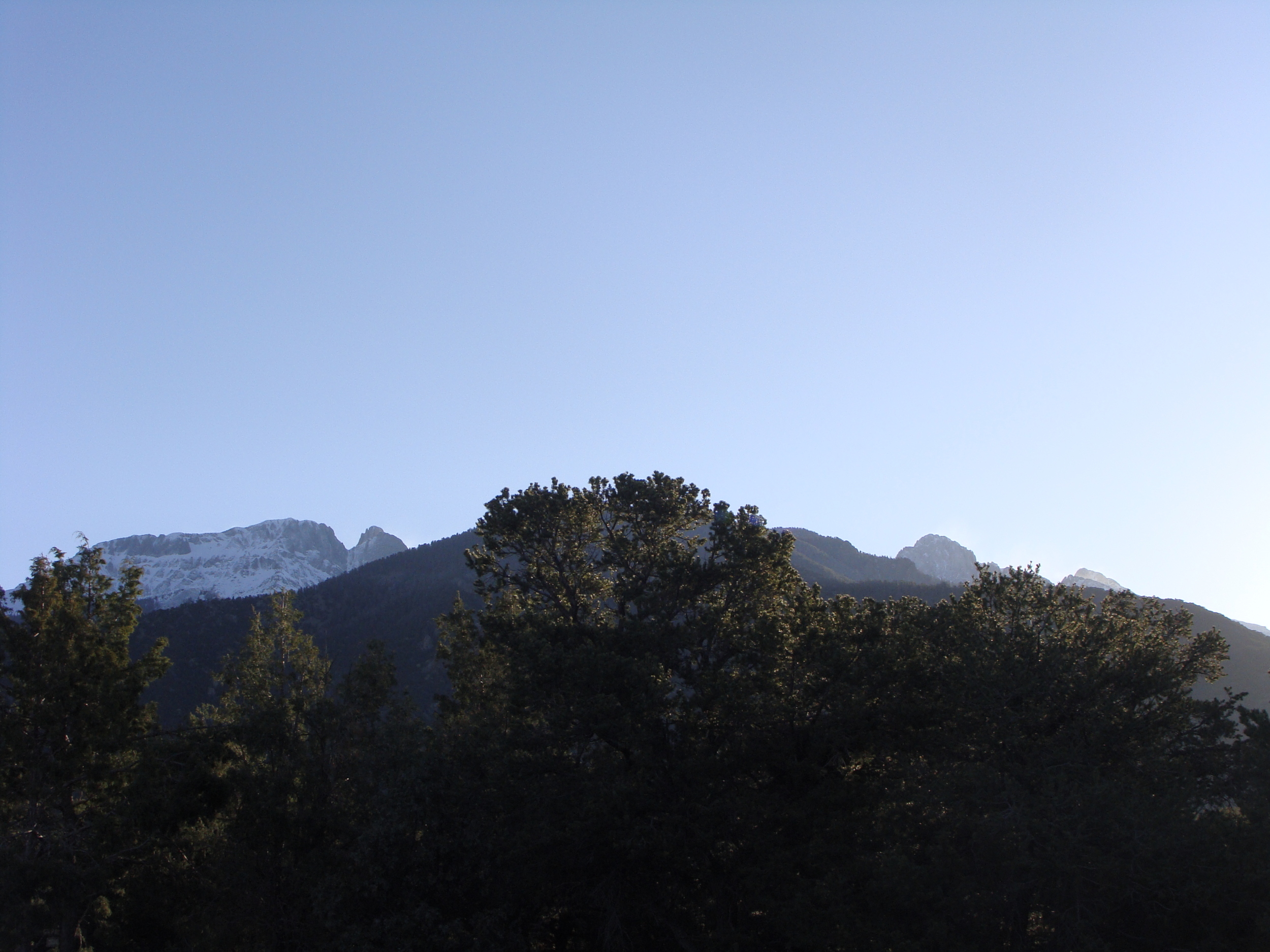 The early morning sun begins to shine on the peaks