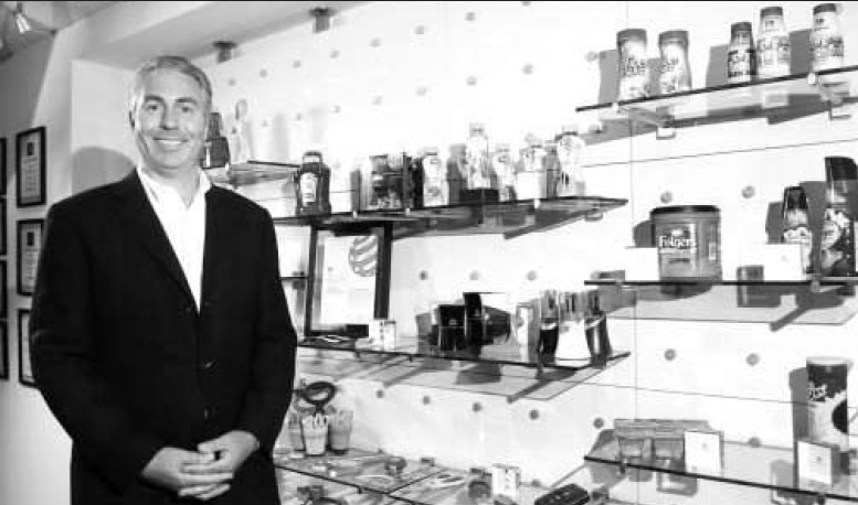 Peter Clarke, founder and CEO of Product Ventures, headquartered in Fairfield, poses with a display of various products the company has designed for companies like Heinz, Folgers and Similac. Clarke's company is celebrating its 15th anniversary