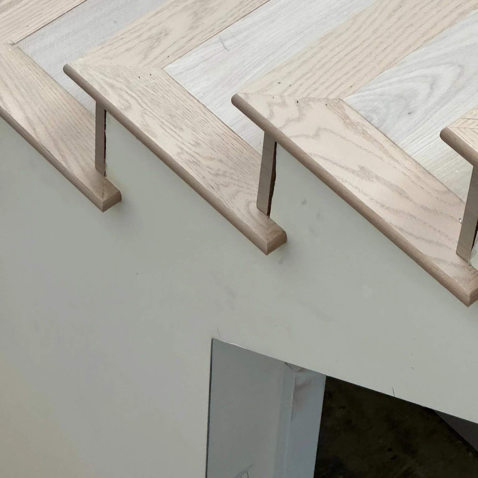 Our latest hardwood flooring installation details the craftsmanship of a beautifully laid floor. 
Take a closer look at the stairs: the plank direction changes and is inset at each step, and the returns are meticulously crafted to enhance the overall