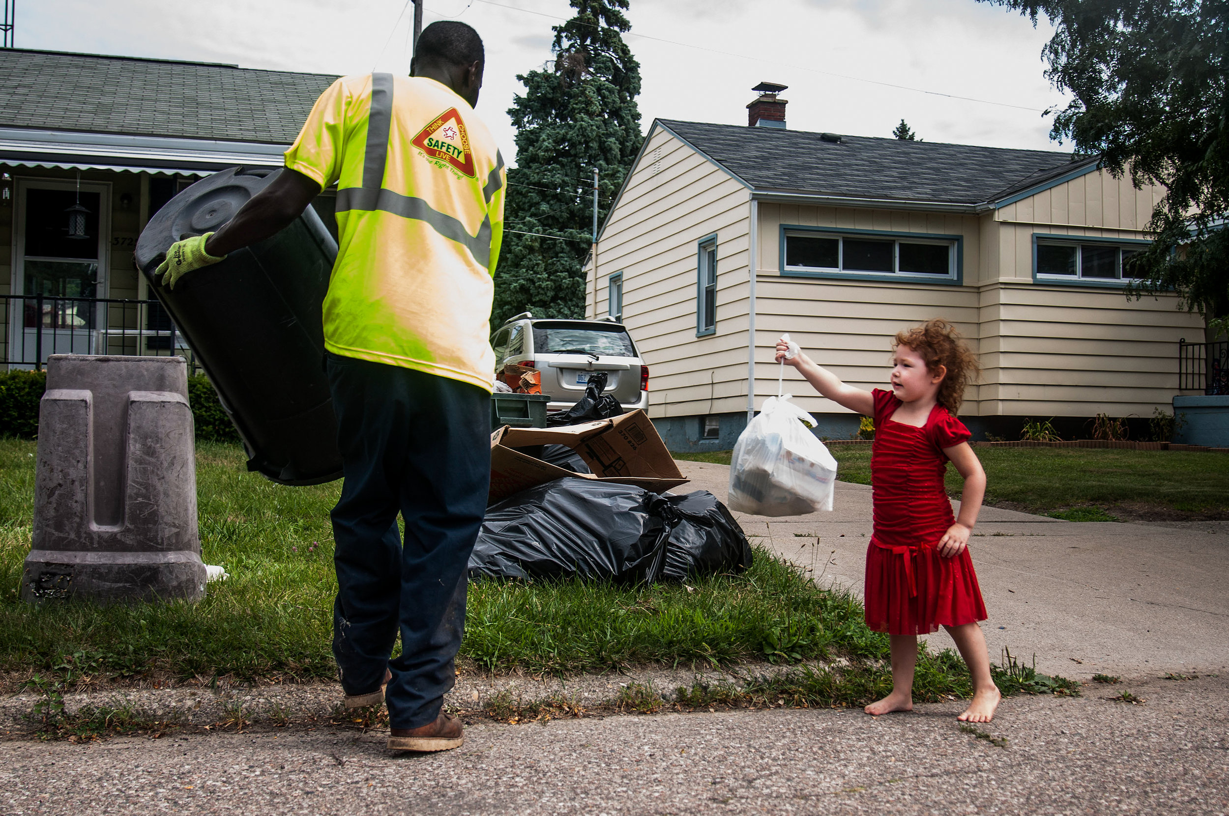 Walter Johnson, an employee of Republic Waste Services, collects garbage from Maricela Gonzalez, 4, of Flint, during his rounds on Friday, August 5, 2016 in Flint, Mich. Republic Waste Services continues to collect trash on an interim basis while the