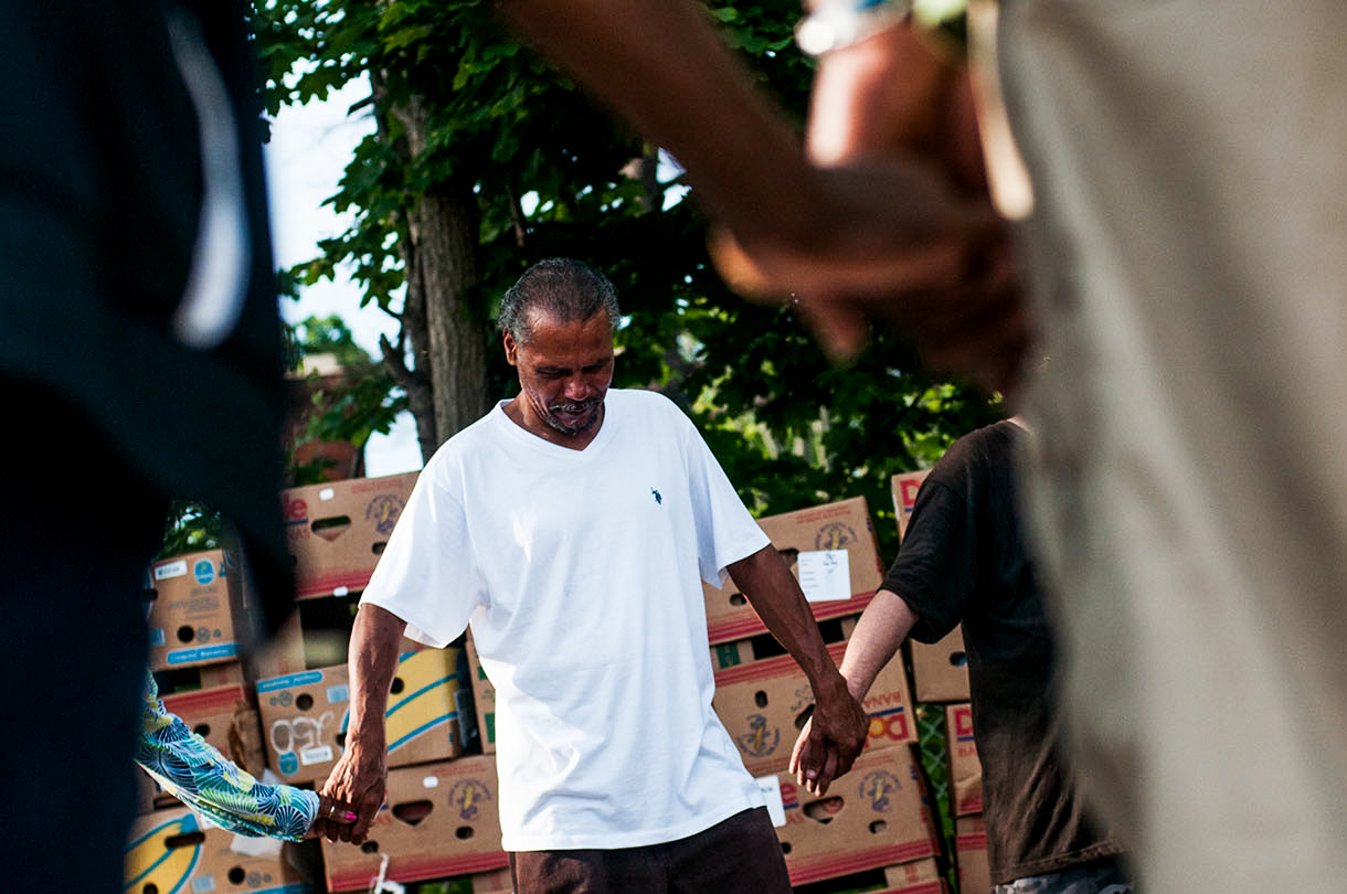 Mike Langford prays over the food before the Christ Enrichment Community's Food Give Away on Friday, August 5, 2016 at Shiloh Missionary Baptist Church in Flint. Every Friday morning around 9 a.m., Christ Enrichment Community and its partners distribute fresh fruits, vegetables, baked goods, hygiene products and other necessities to the community.