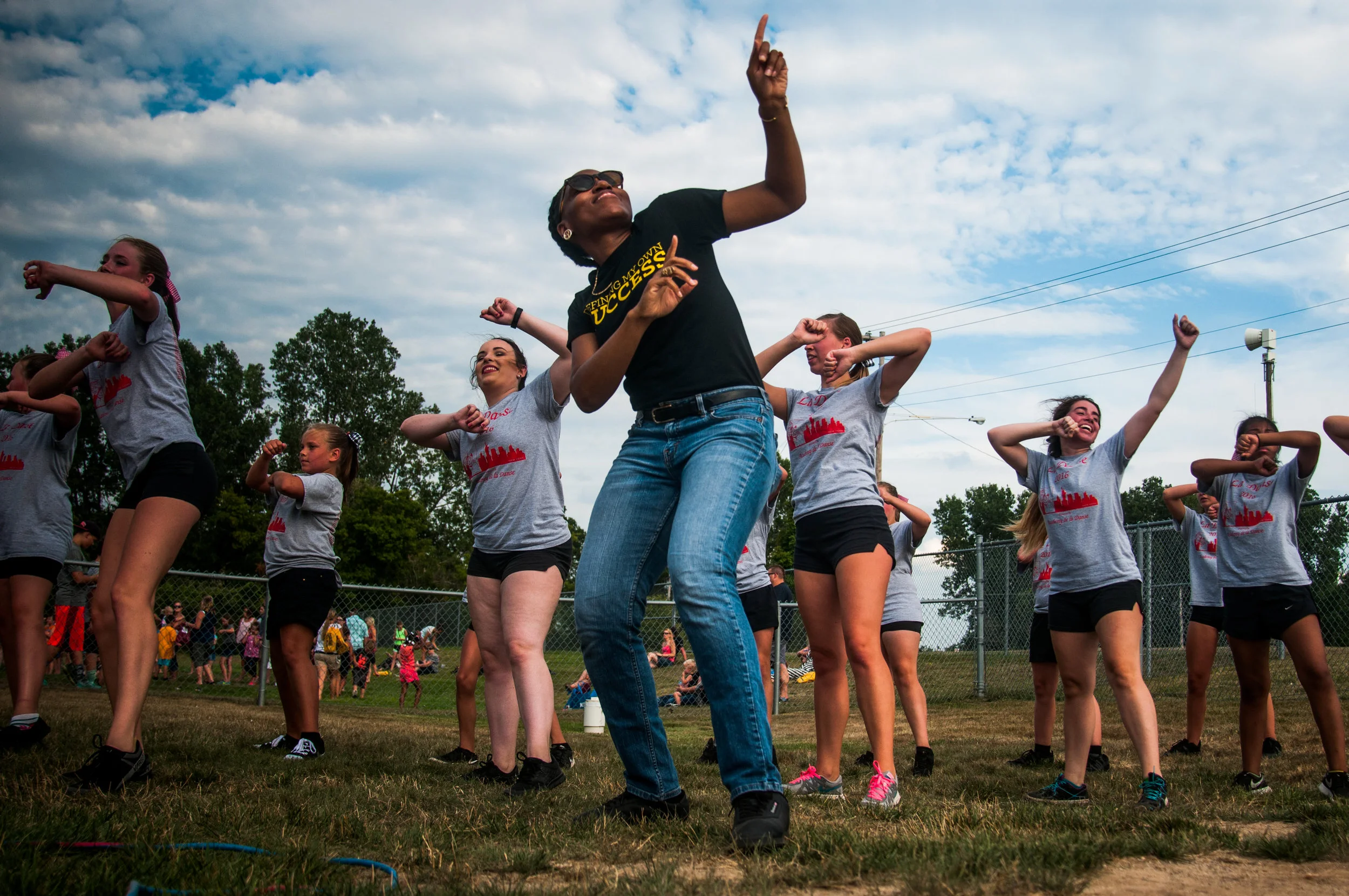 Nana Dompreh, of Flint, dances with the girls of De La Danse during the Davison Community Schools Back to School Blast on Tuesday, August 9, 2016 at Cardinal Stadium in Davison.