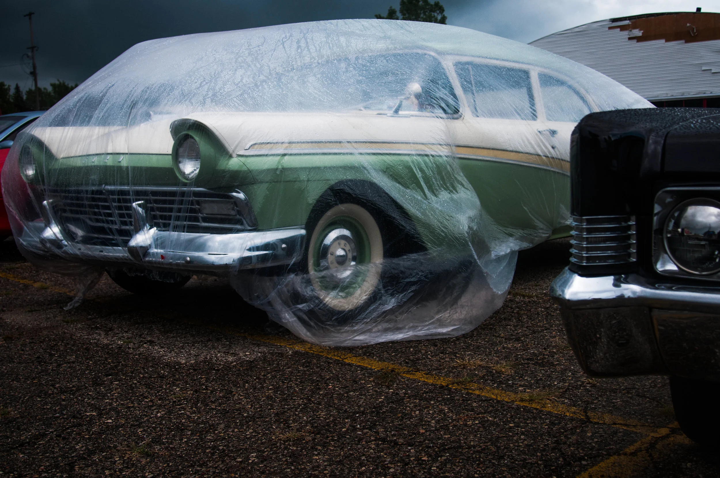 A car is covered by a plastic tarp to protect it from the rain while on display at the Mount Morris Tune Up event on Saturday, Aug. 13, 2016 in Mount Morris. The final tune up event offered an opportunity for the community to view a variety of classic cars on display before Back to the Bricks week. 