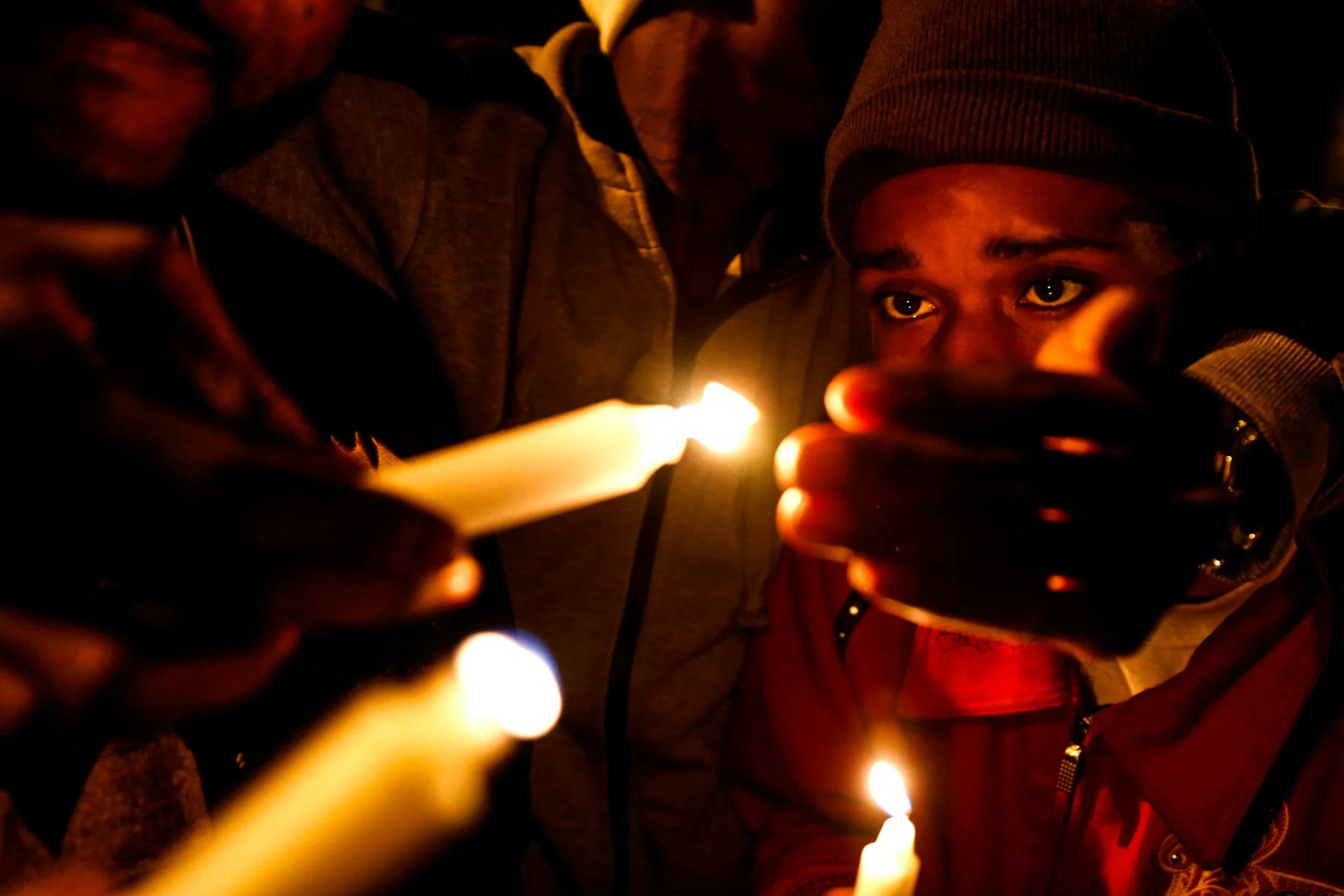 James Mason Jr., a Flint native and long-time friend of Donte Williams, lights candles with other friends and family of Williams to remember and to celebrate his life during a vigil service on Sunday, Oct. 23, 2016 at the Flat Lot in downtown Flint, Mich. Earlier that day, Williams was shot multiple times and killed at the lot. "We ain't have to be blood to be brothers," Mason said of his friend of almost 15 years. "Sometime water is thicker than blood when you've been through the mud. That's how we was."
