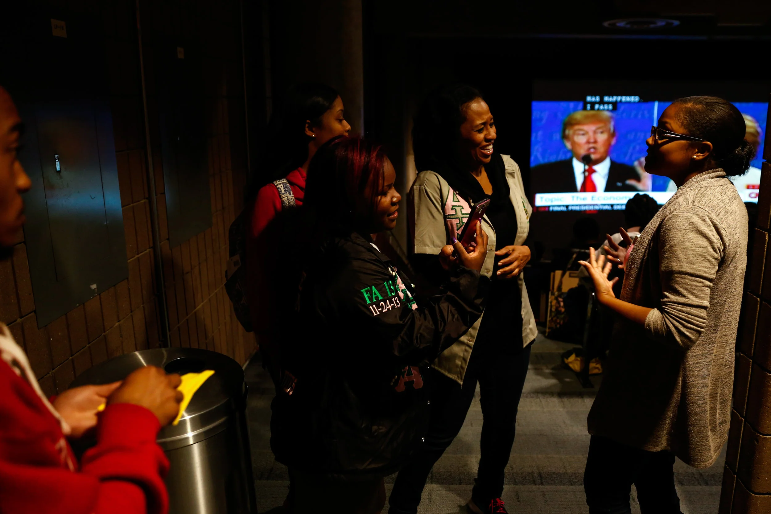 Corey Taylor, a graduate advisor for Alpha Kappa Alpha Sorority, Inc., laughs while talking to Diamond Wilder, a senior at UM-Flint, right, while gathering with over 30 students, faculty, staff and community members in the Kiva to watch the Presidential debate on Wednesday, Oct. 19, 2016 at UM-Flint in downtown Flint. "You need to be aware...and able to advocate for what you think is right for our country...and on a local level within your community," said Phaejare Thomas, president of Alpha Kappa Alpha Sorority, Incorperated Xi Chi chapter and a senior nursing student at UM-Flint.