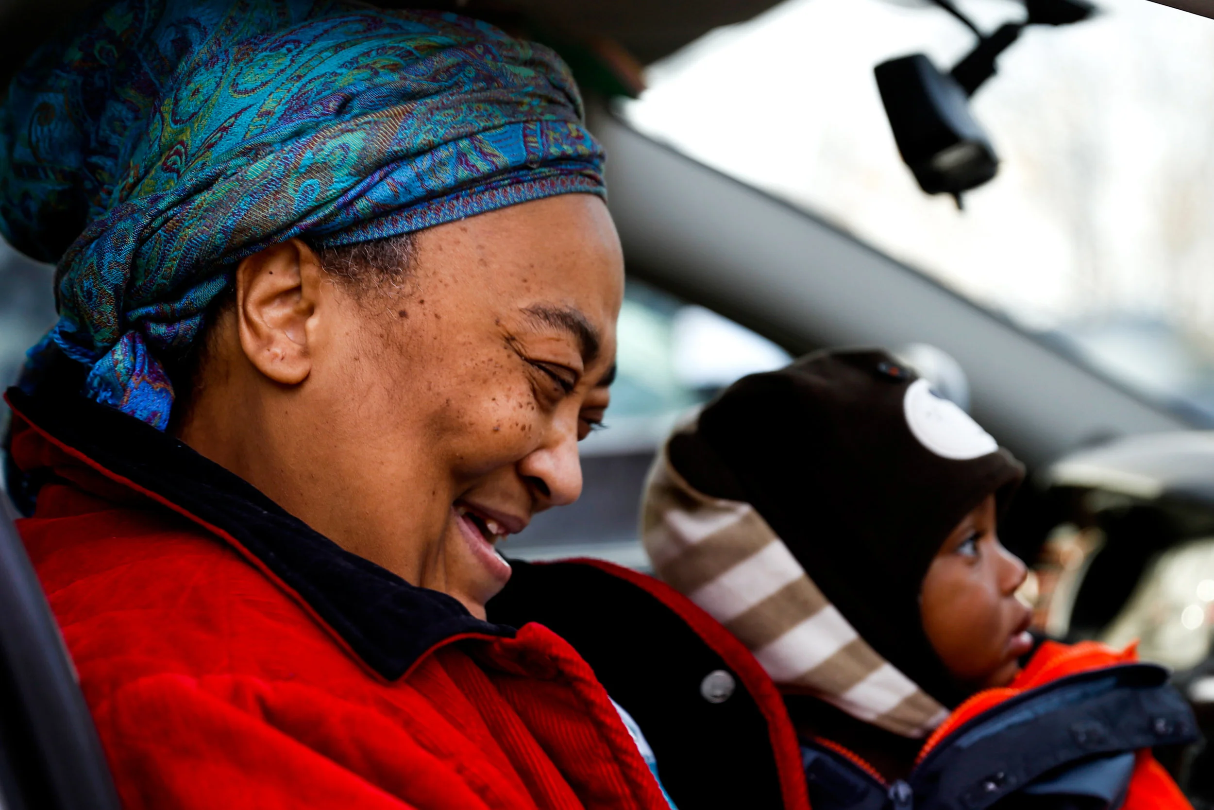 Patricia Brewster, of Flint, sits in with her 10-month-old grandson Amari Thompson while talking to a friend at the Morris Peterson Foundation's meal box distribution on Tuesday, Nov. 22, 2016 at Saint Mark Missionary Baptist Church in Flint. The Morris Peterson Foundation helped to provide a Thanksgiving dinner to families in Flint for the third consecutive year. "It's just great to see the smiles on people's faces when they come in to pick their boxes up," Peterson said.