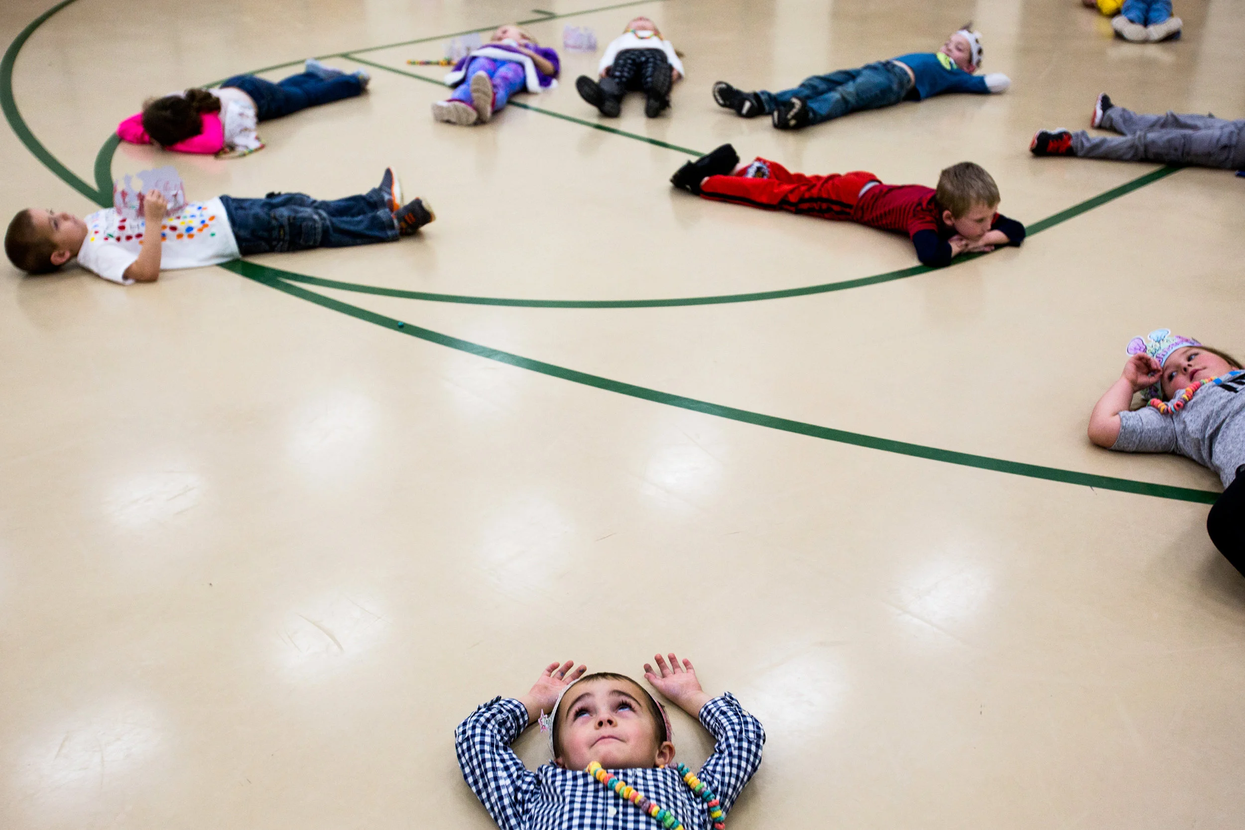 Pine Ridge Elementary kindergartner Alexander Crowley laid on the ground in silence for 100 seconds after completing 100 jumping jacks during the 100th day of school celebration Thursday at the school in Kyana. Forty-eight kindergartners celebrated the 100th day in the school gymnasium with a variety of activities, including the jumping jacks, 100 cupcakes and counting games.