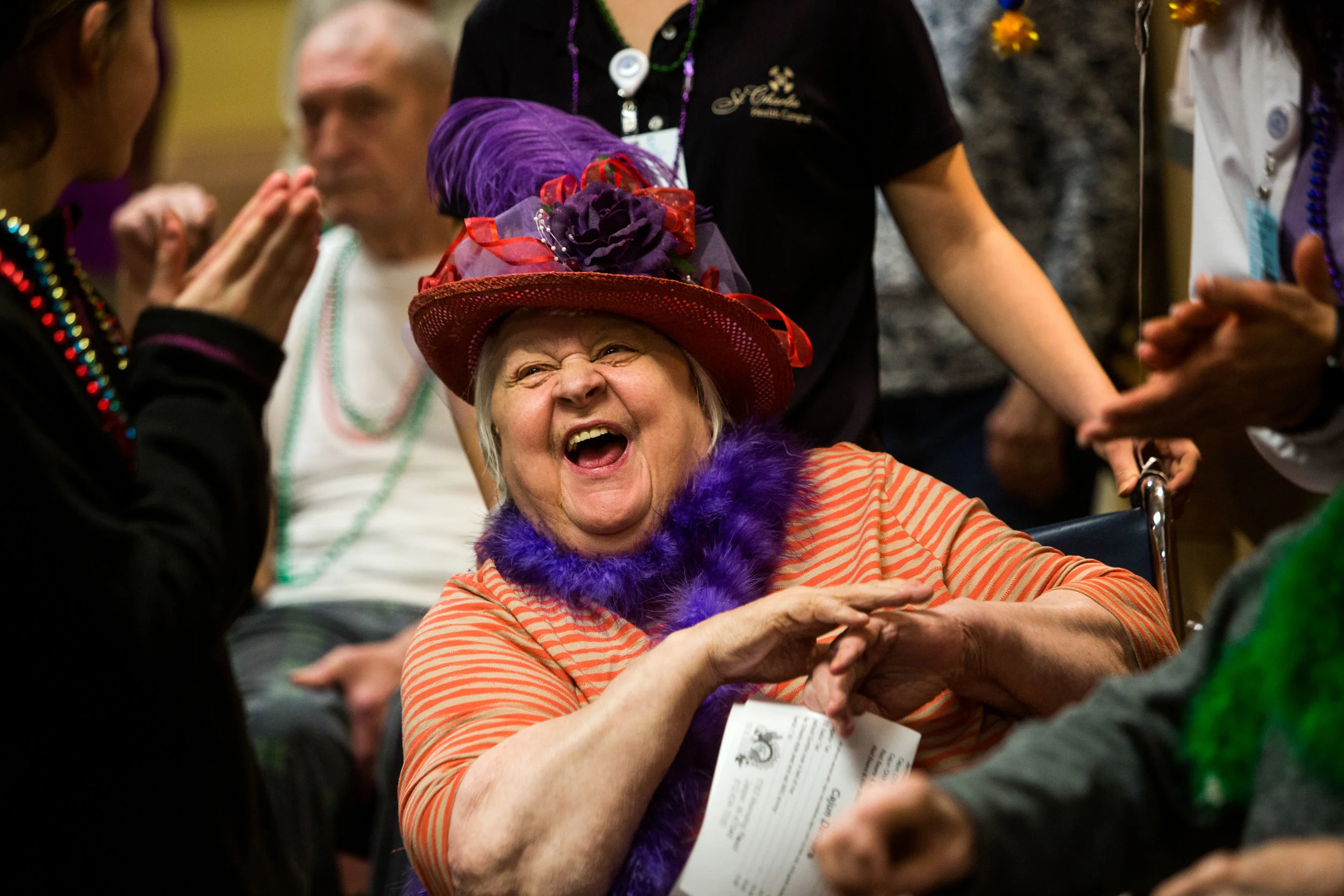 St. Charles Health Campus resident Jane Flores clapped after a Mardi Gras celebration on Tuesday afternoon at the living center in Jasper. Residents dressed up in purple, green and gold, wheeled around the building and answered Mardi Gras trivia questions while celebrating Fat Tuesday. 
