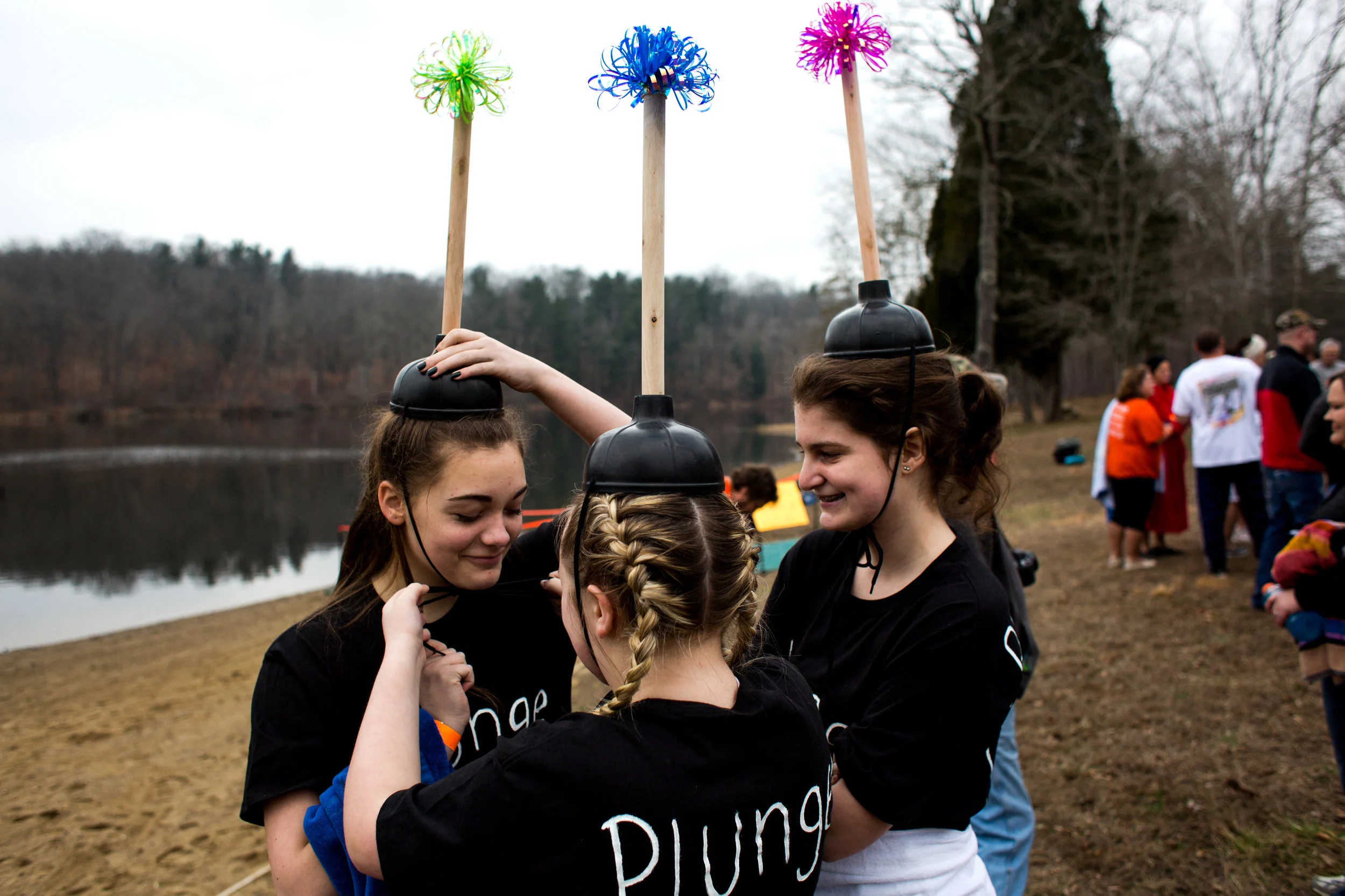 Gracie Graves of Ferdinand, 13, middle, secured a plunger hat on Kristen Detty of Birdseye, 13, before participating with Kendall Barth of Ferdinand, 13, right, in the annual Plunge for Dubois County on Sunday afternoon at Ferdinand State Forest in Ferdinand. Proceeds from the event benefited the Lange-Fuhs Cancer Center, Dubois County Leukemia Association and area food banks.