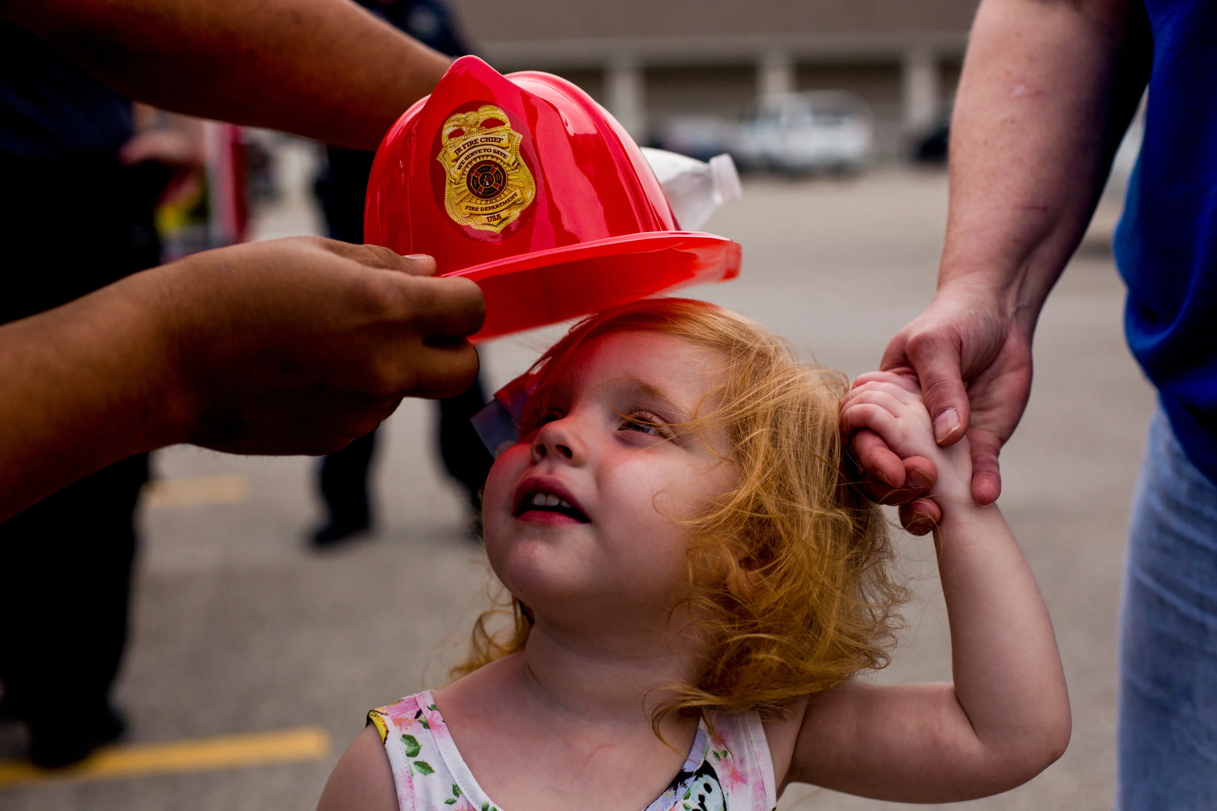 Lauren Pitrowski of Jasper, 2, held the hand of her grandmother, Jeannine Martin of Jasper, as a Jasper firefighter tried to place a hat on her head during the Fifth Street School Community Health Fair on Thursday in Jasper. More than 30 vendors set up at Fifth Street to promote healthy living with nutritious snacks and several activities for families to enjoy. 