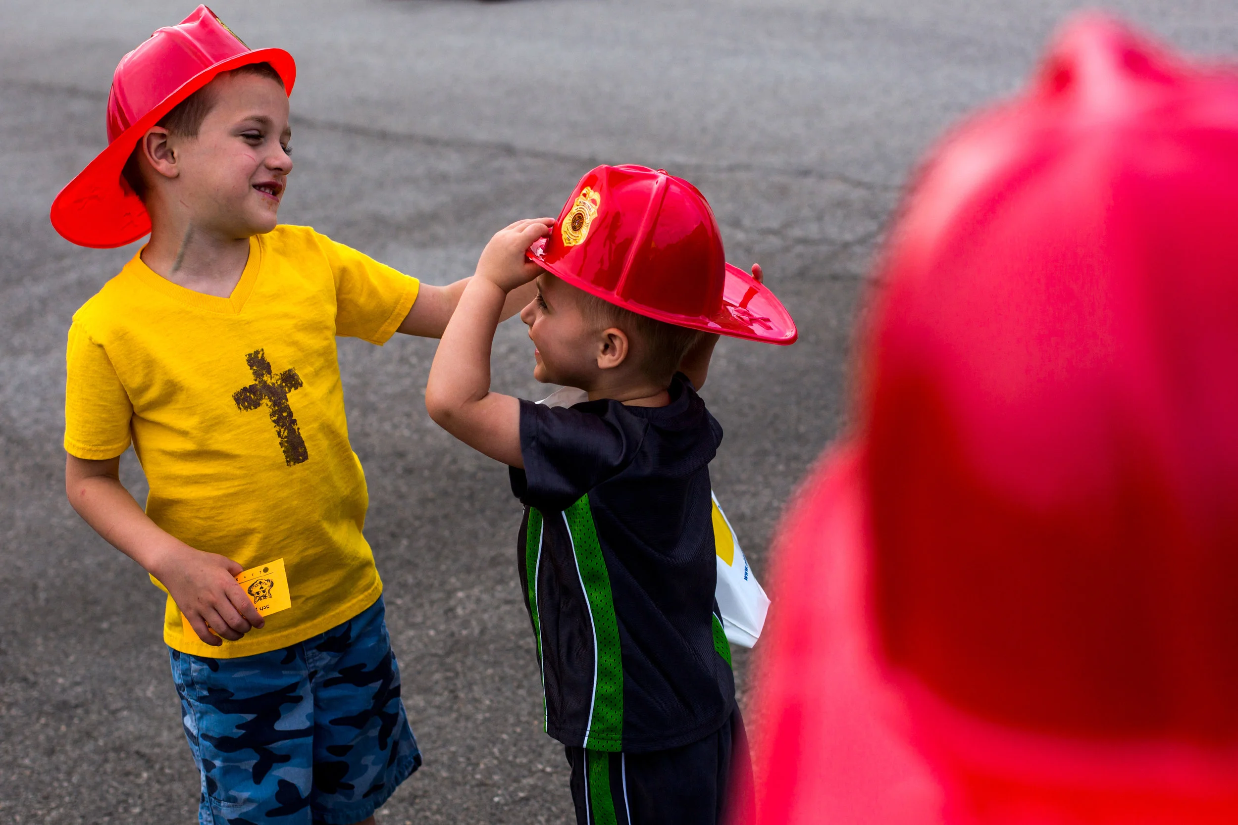 Grant Gehlhausen of Ireland, 8, watched his younger brother, Cash, 4, left, help Max, 2, adjust the hat he received from the Jasper Volunteer Fire Department during the Fifth Street School Community Health Fair on Thursday in Jasper. More than 30 vendors set up at Fifth Street to promote healthy living with nutritious snacks and several activities for families to enjoy. 
