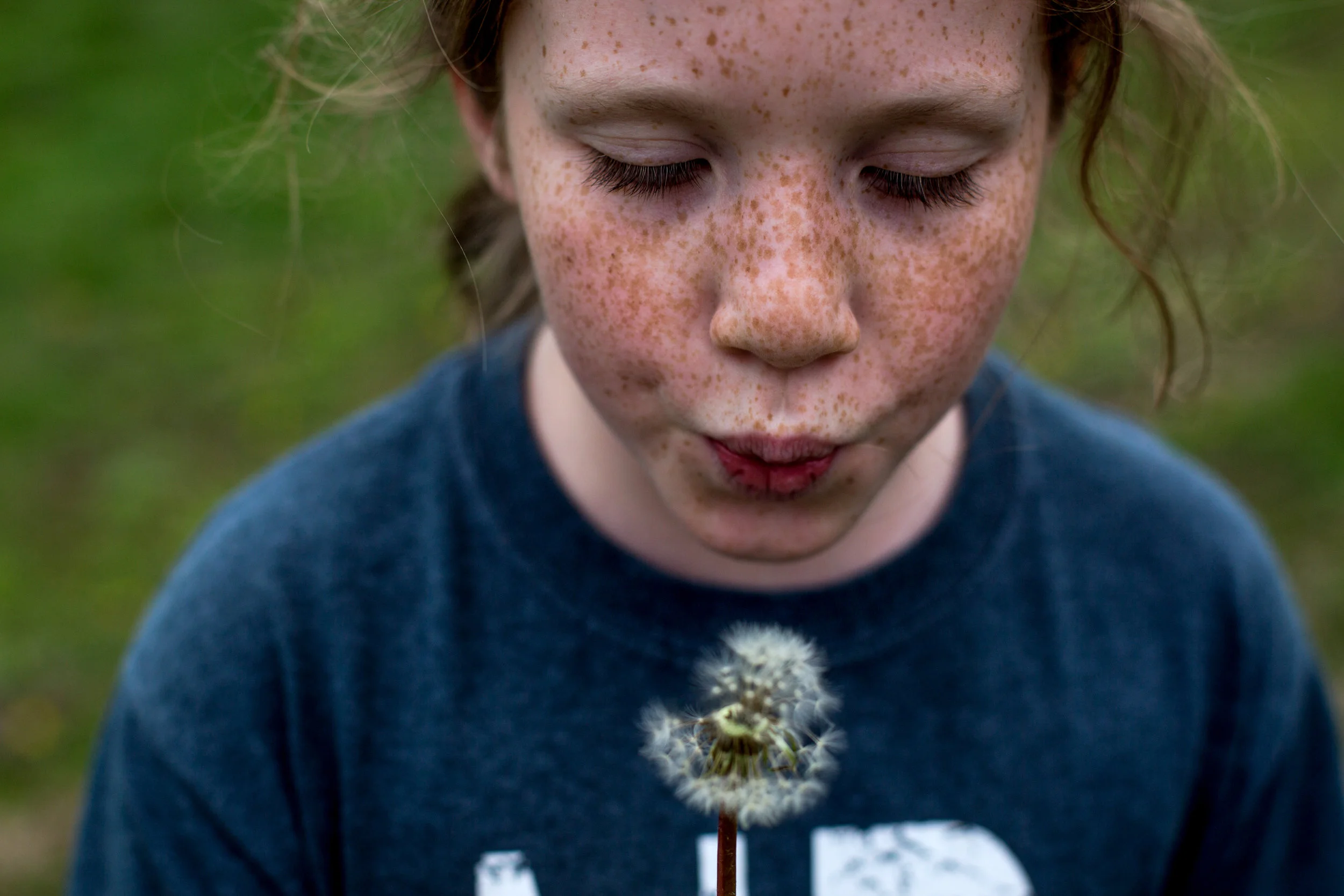 Madelyn Schepers of Dubois, 10, blew on a dandelion while fishing at her grandmother's pond in Dubois on Tuesday during spring break.