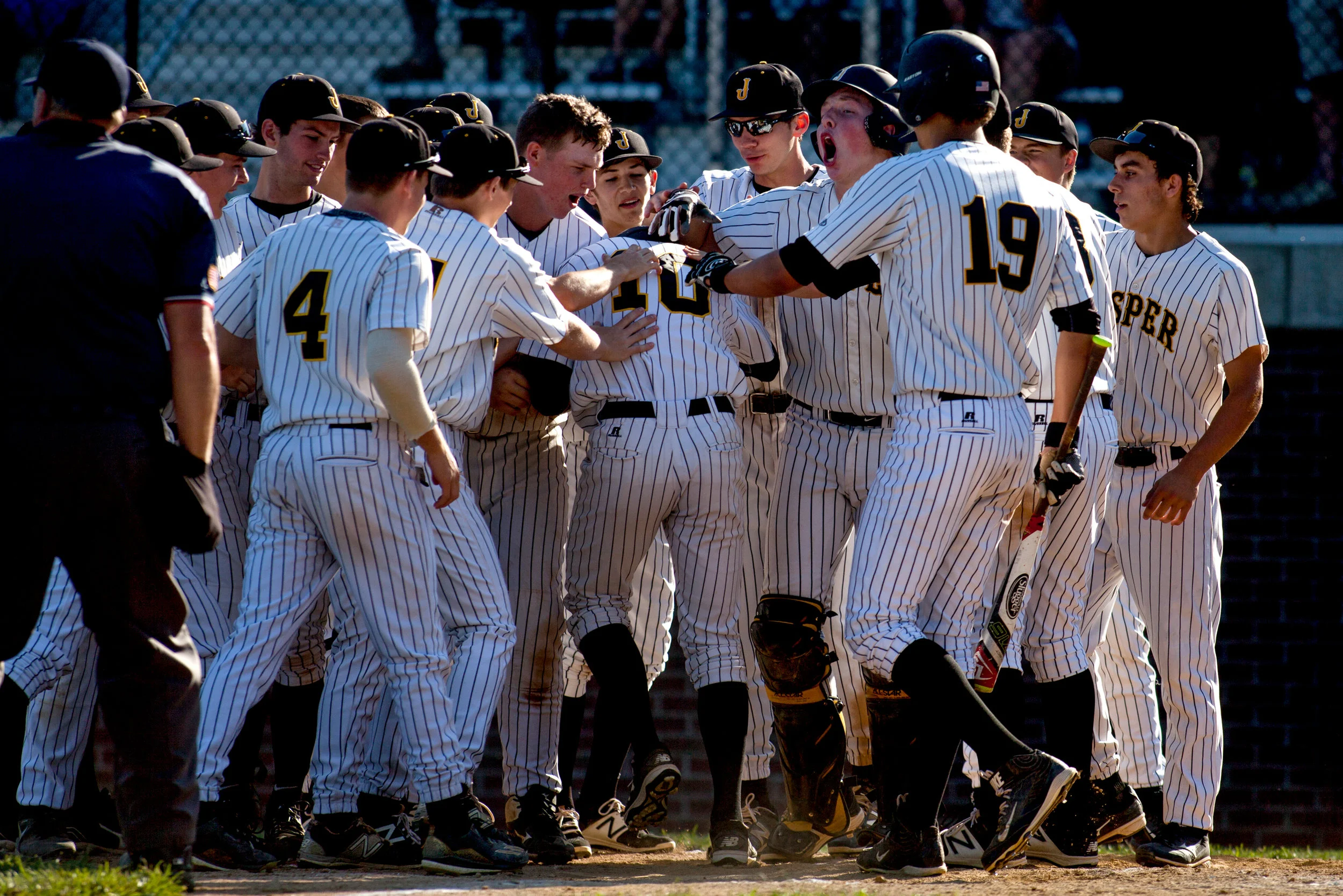 Jasper players congratulated Jared Sermersheim as he reached home plate after hitting a home run during the Indiana Baseball Hall of Fame Classic championship game at Ruxer Field in Jasper on Saturday. Jasper lost to Lake Central 9-3. 