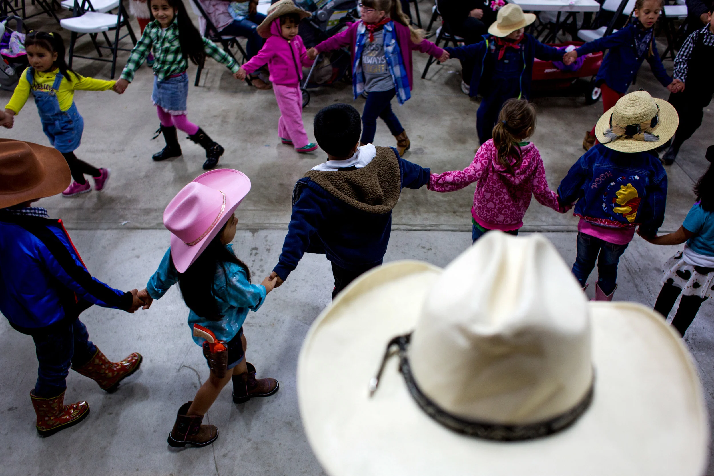 Edwin Pacas of Jasper sat with his daughter, Aneily, 4, and watched children dance in a circle during Tri-Cap’s Head Start preschool program Wednesday at the Dubois County 4-H Fairgrounds in Bretzville. 