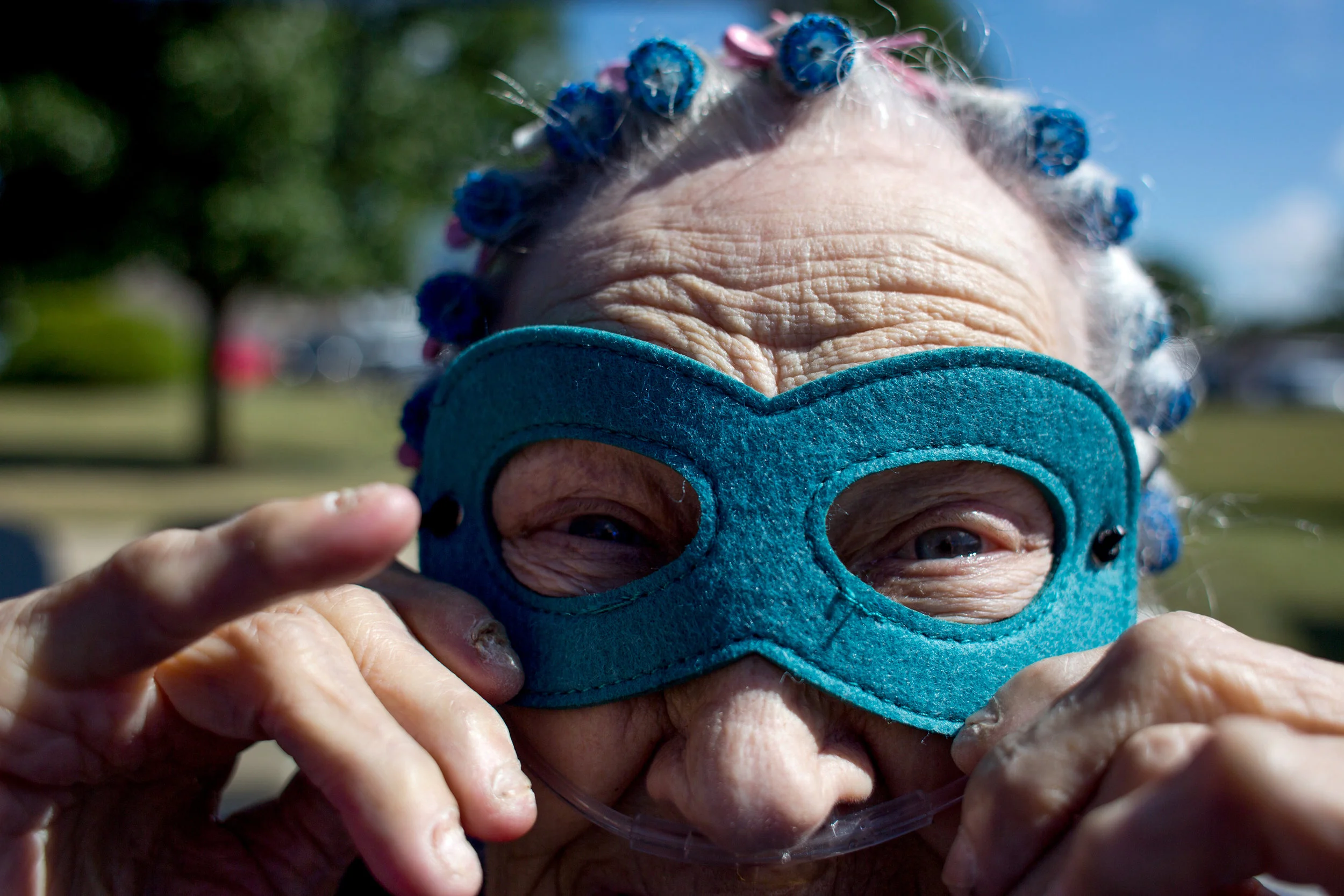 St. Charles Health Campus resident Betty Wenzel adjusted her superhero mask before welcoming cyclist during the fifth annual Trilogy 200 Wellness Tour on Thursday at the senior living facility in Jasper.