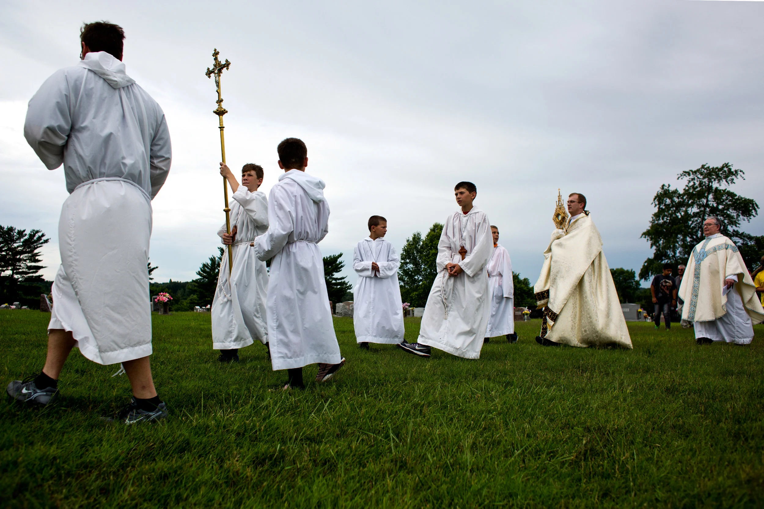 Father Ryan Hilderbrand, second from right, carried the sacrament of monstrance through the cemetery behind St. Mary's Catholic Church to the alter during a Corpus Christi procession Sunday in Huntingburg.