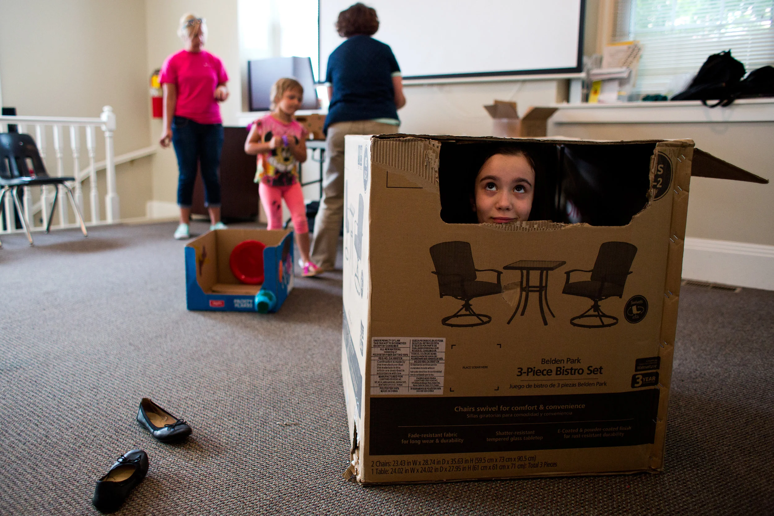 Madeline Zipp-Nathan of Jasper, 9, peeked out of the box she was decorating during Thursday’s Cardboard Car Project at the Jasper Library Annex. The library provided paint, stickers, plastic plates, cups and more for children to decorate their boxes.