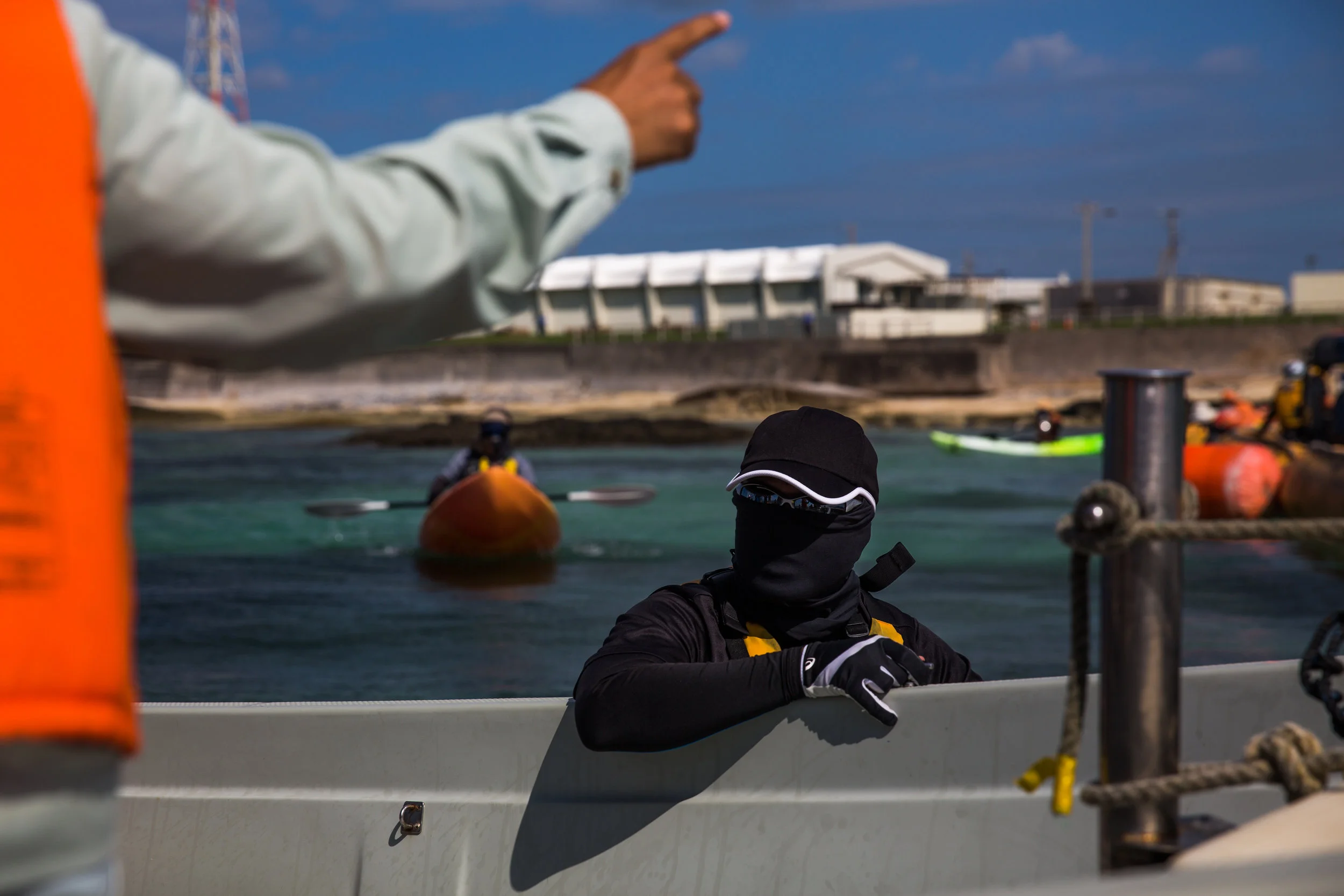 A member of Henoko Blue, a civilian canoe team, paddles out to peacefully protest the construction of a new U.S. military base in Oura Bay, Okinawa. The project involves dumping 21 million cubic meters of soil into the "sea of treasures," threatening