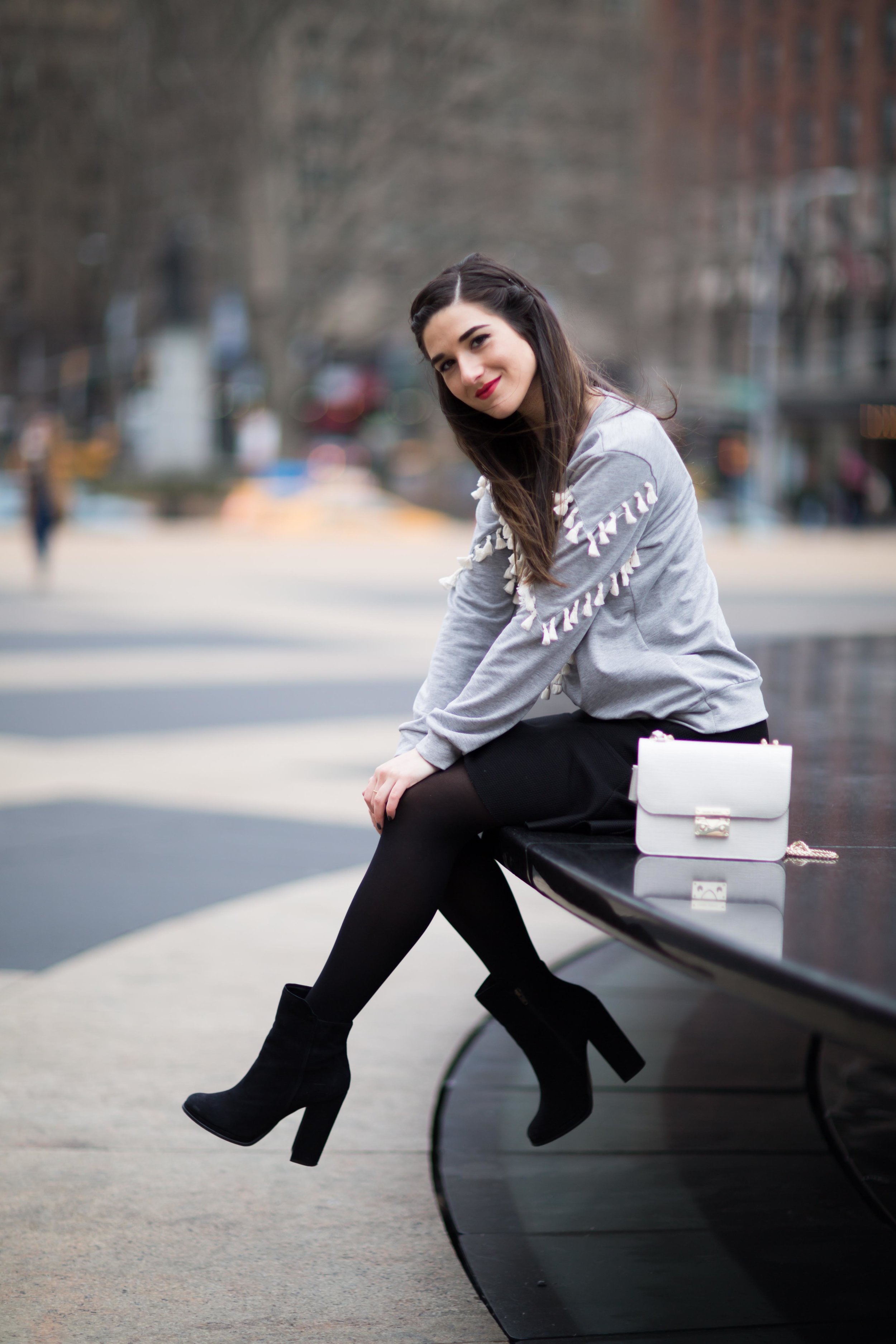 Grey Tassel Sweatshirt Everything You Wanted To Know About Blog Interns Esther Santer Fashion Blog NYC Street Style Blogger Outfit OOTD Trendy Henri Bendel Waldorf Party Bag Black Mini Skirt Booties Shoes Cozy Tights Photoshoot Model Girl Women Hair.jpg