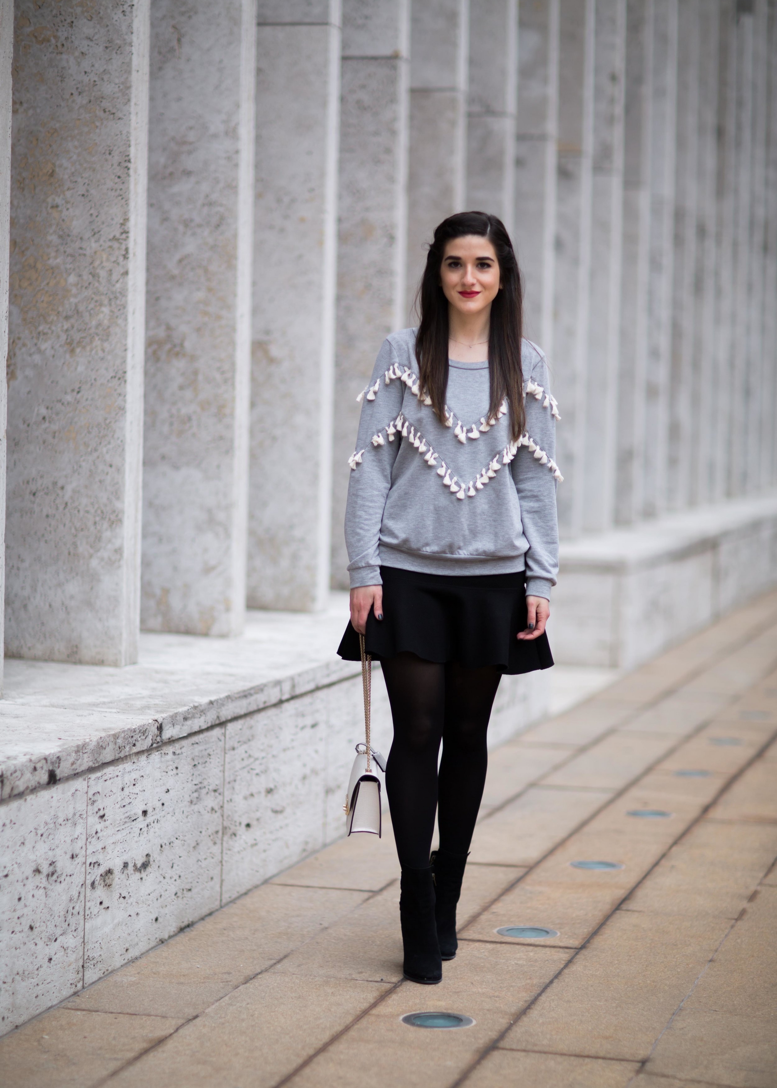 Grey Tassel Sweatshirt Everything You Wanted To Know About Blog Interns Esther Santer Fashion Blog NYC Street Style Blogger Outfit OOTD Trendy Henri Bendel Waldorf Party Bag Black Mini Skirt Booties  Shoes Cozy Tights Photoshoot Model Girl Women Hair.jpg