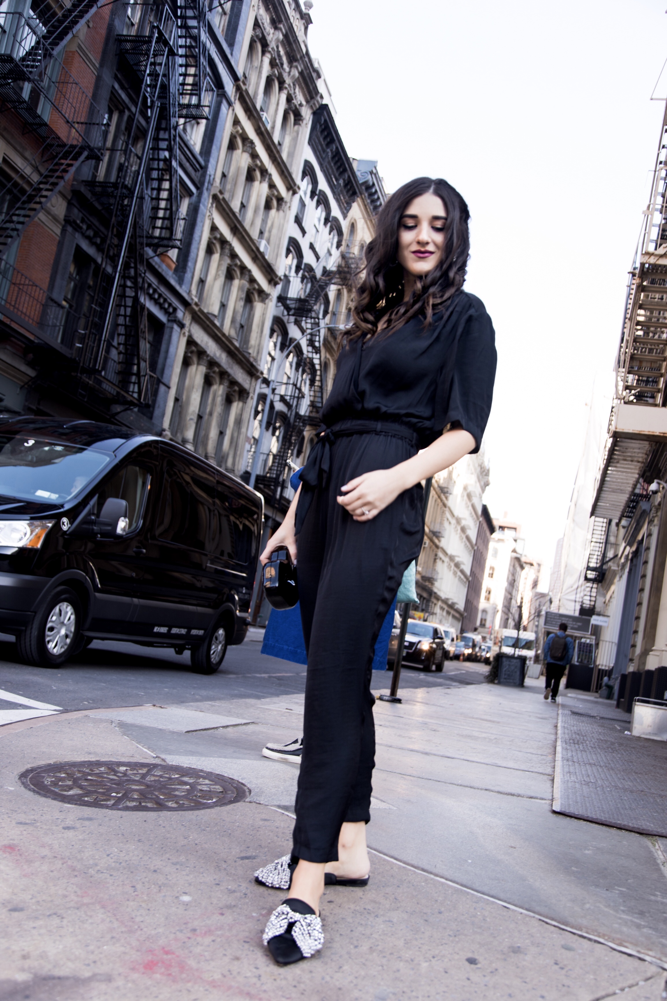 Where We're Going For Our Honeymoon Black Silk Jumpsuit Bow Mules Esther Santer Fashion Blog NYC Street Style Blogger Outfit OOTD Trendy Urban Outfitters Betsey Johnson Soho Collab Jeweled Shoes Earrings Braid Hairstyle Hoops  Necklace Lips Clutch Bag.jpg