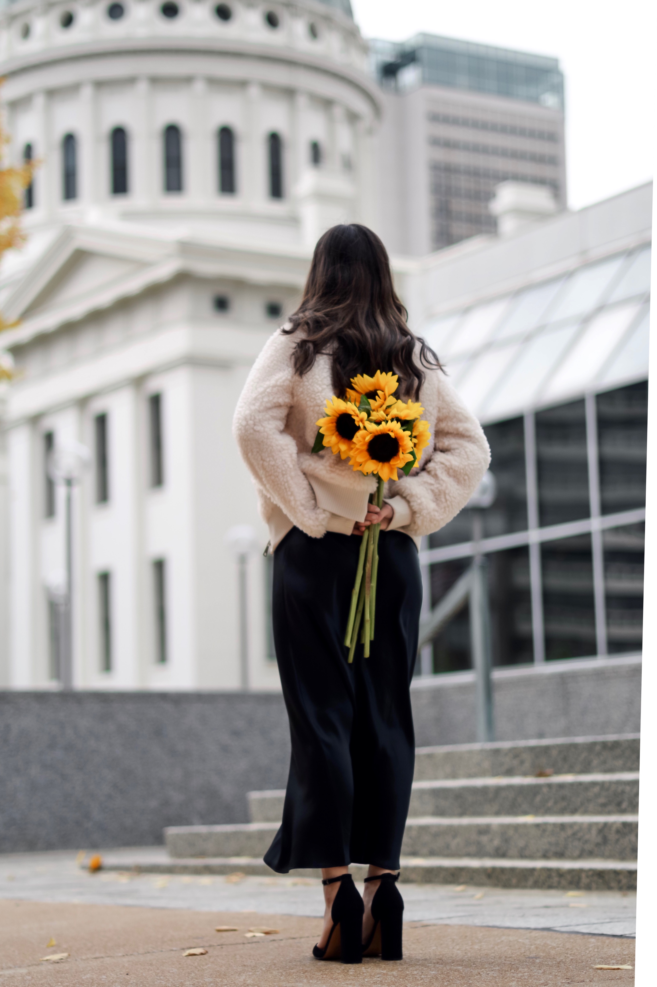 The 10 Most Frustrating Parts Of Brand Collabs Long Black Slip Dress Shearling Jacket Esther Santer Fashion Blog NYC Street Style Blogger Outfit OOTD Trendy Shopping St. Louis Photoshoot Hometown Downtown Saint Louis Sunflowers Yellow  Flowers Heels.jpg