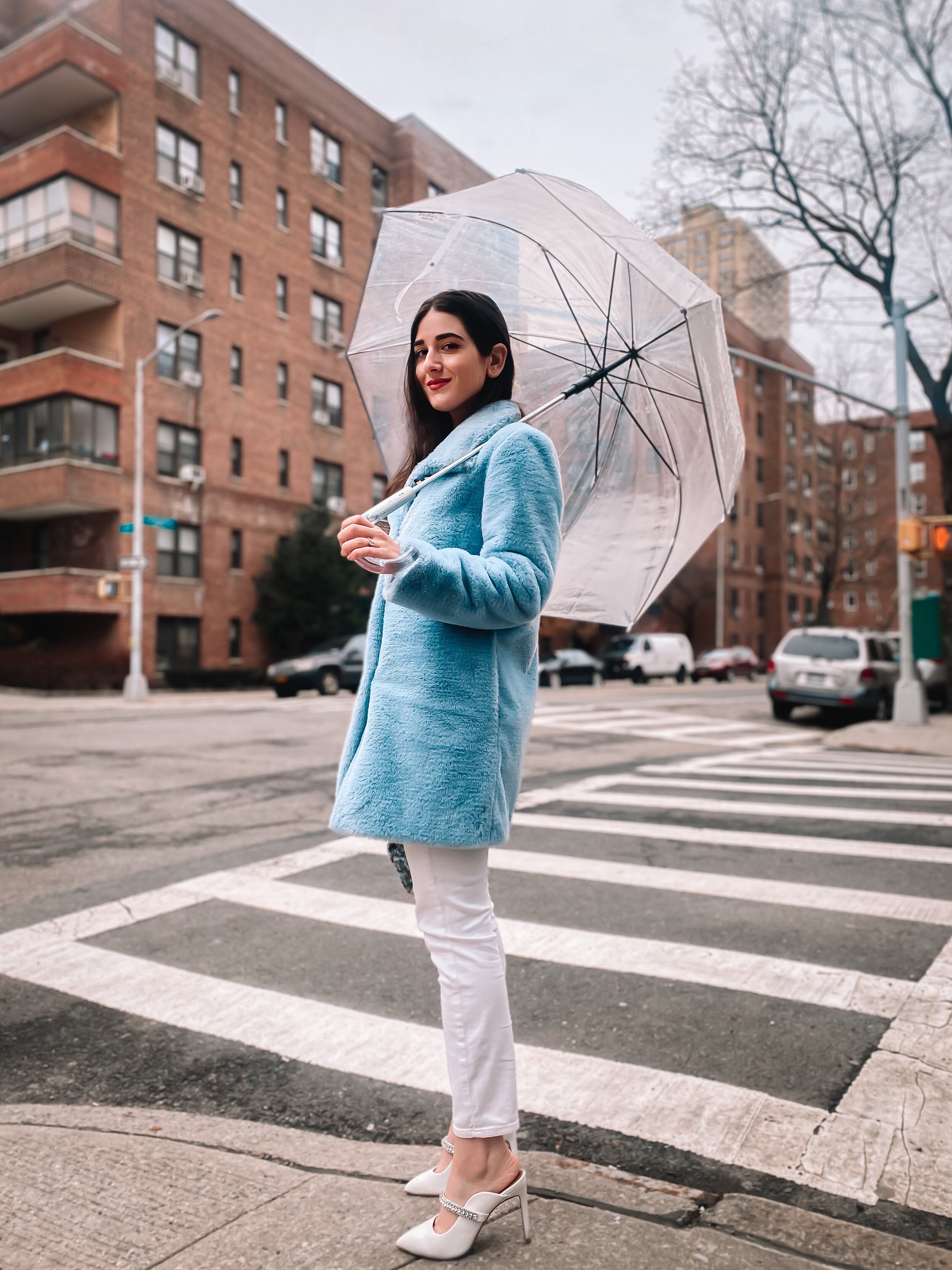 Esther Santer NYC Street Style Fashion Blogger New York City What To Wear Casual Shop Buy Girl Women Baby Blue Faux Fur Coat Calvin Klein Target Clear Dome Umbrella White Jeans 7 For All Mankind Kurt Geiger Duke White Jewel Heels Tripod Photo Rainy.JPG