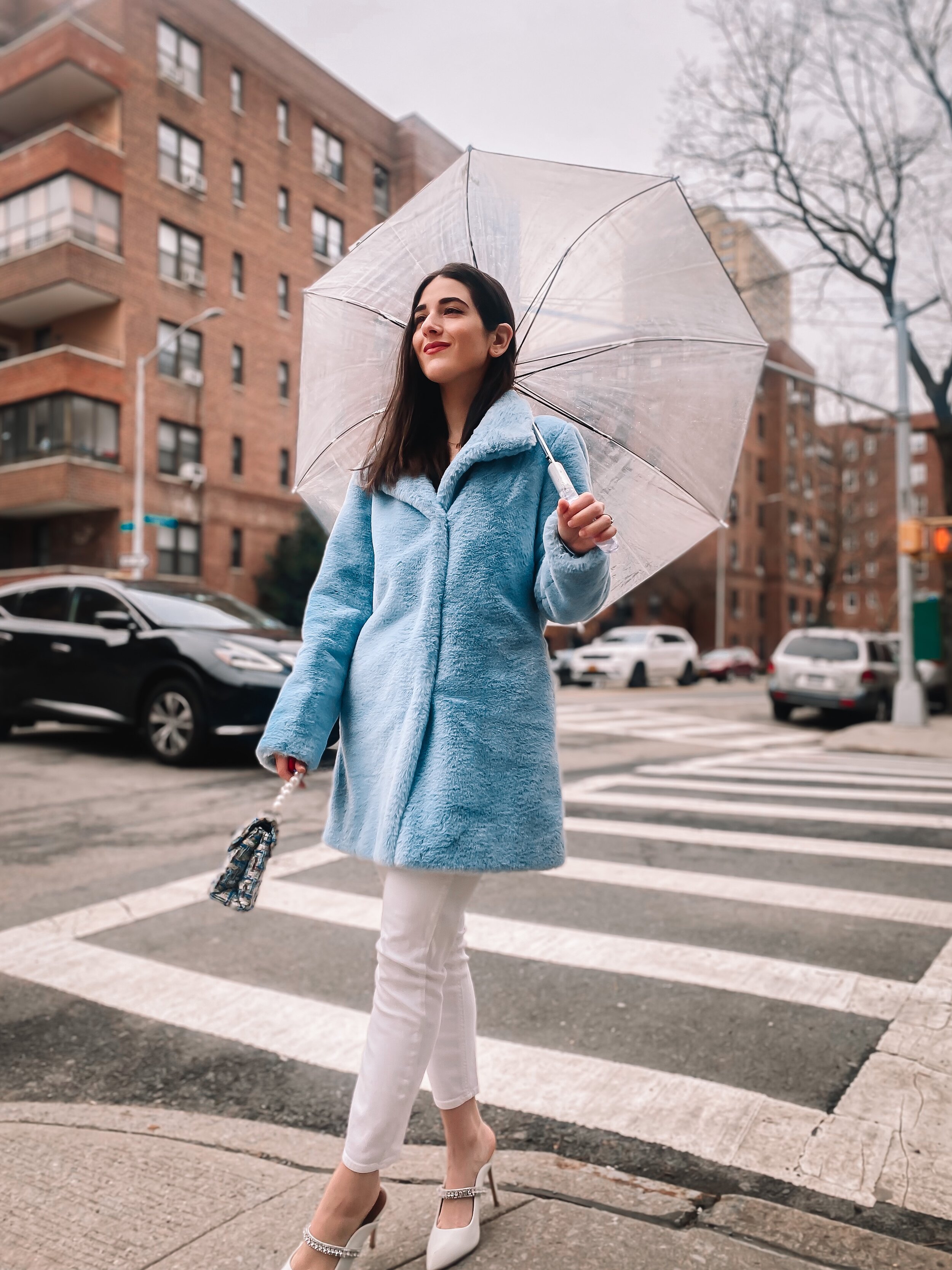 Esther Santer NYC Street Style Fashion Blogger New York City What To Wear Casual Shop Buy Girl Women Baby Blue Faux Fur Coat Calvin Klein Target Clear Dome Umbrella White Jeans 7 For All Mankind Kurt Geiger Duke White Jewel Heels Tripod Photo  Rainy.JPG