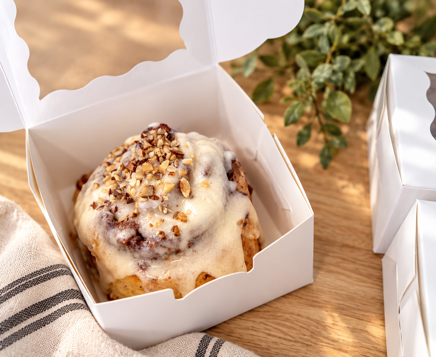 Iced Pecan Cinnamon Roll in Bakery Box.png